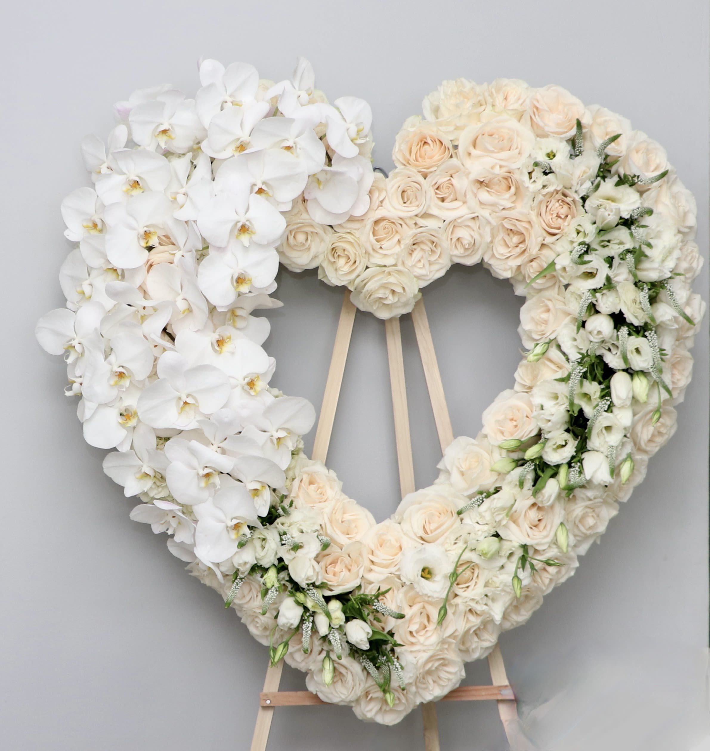 Orchid Dream Heart Orchid Dream Heart - This elegant sympathy heart wreath is made with white roses and a graceful cascade of orchids down one side with other white florals are included. We include easel, printed banner and delivery (some fees may apply). An additional banner can be added for $15. Standard size is 30'', deluxe is 36'', and premium is 42''.