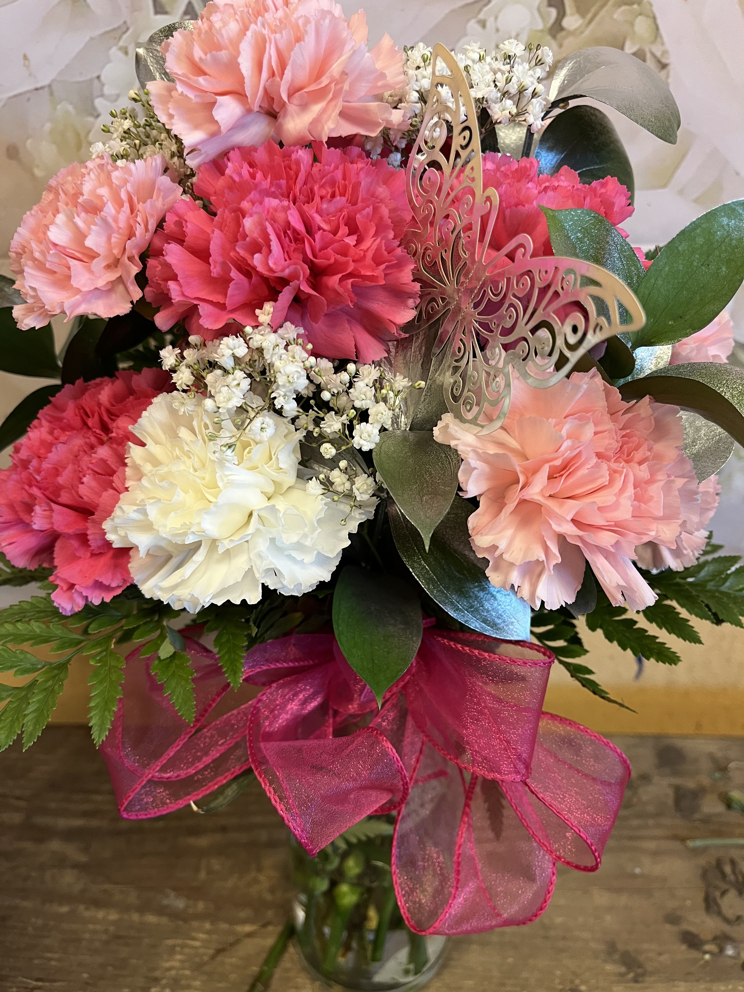 Pink and White Carnation Vase Arrangement Pink and White Carnation Vase Arrangement - 12 Carnations in a vase. In the colors shown White, Pink and Hot pink and the fillers will be silver ruscus and baby breath Deluxe Includes 18 Carnations Premium Includes 24 Carnations