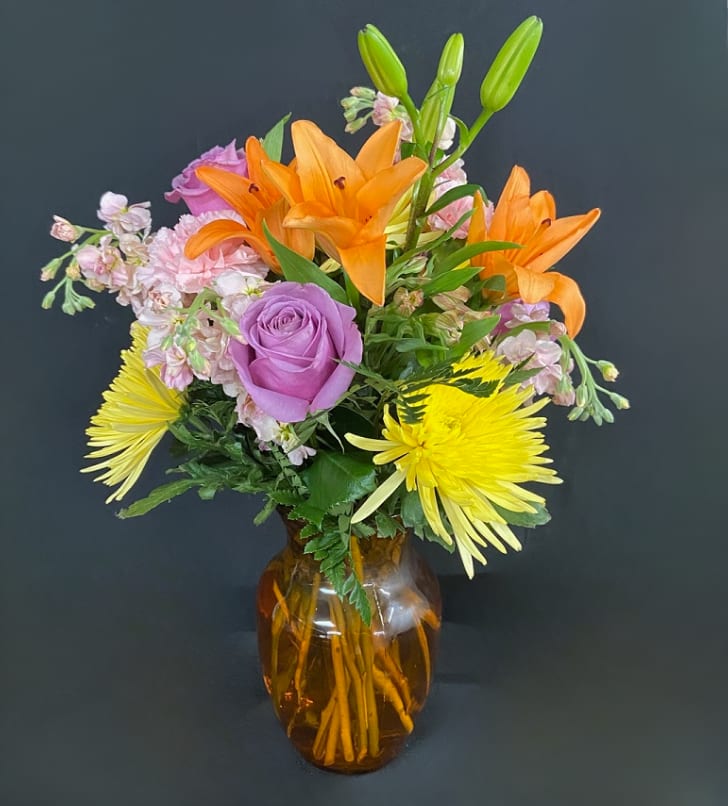 Fall Fun! Fall Fun! - What's more fun than flowers? Celebrate Fall all year round with this beautiful arrangement of fall colored flowers including orange lilies, purple roses, yellow fuji mums, cream stock, and orange alstro.