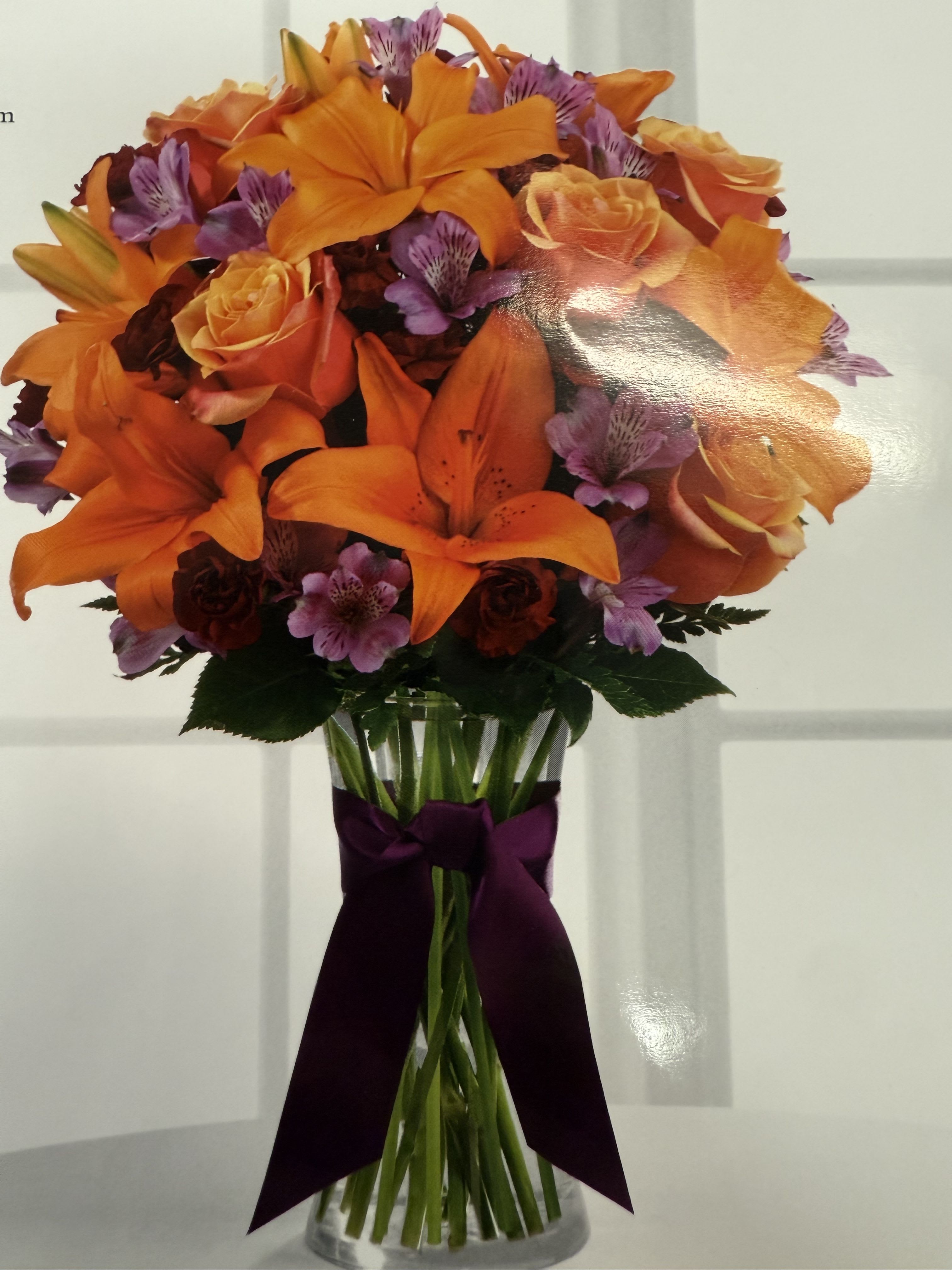 Happiness and Love Happiness and Love - A wonderful arrangement composed of orange lilies, purple alstroemeria, orange roses, burgundy carnations, and hints of greens.