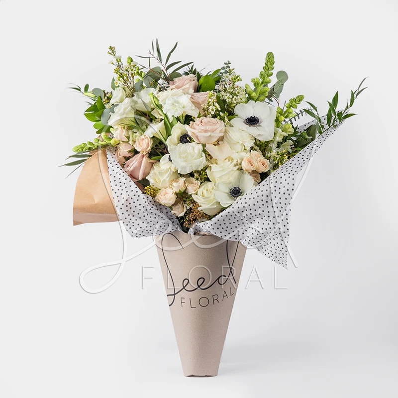 Neutral Bouquet - Designed in house with love, this One sided bouquet featuring seasonal blooms in a soft neutral palette of whites, creams, &amp; blush tones wrapped in a decorative layer of foliage &amp; filler. Bouquet arrives designed, hand-tied with hydration packet in our Signature Bouquet Wrap.   