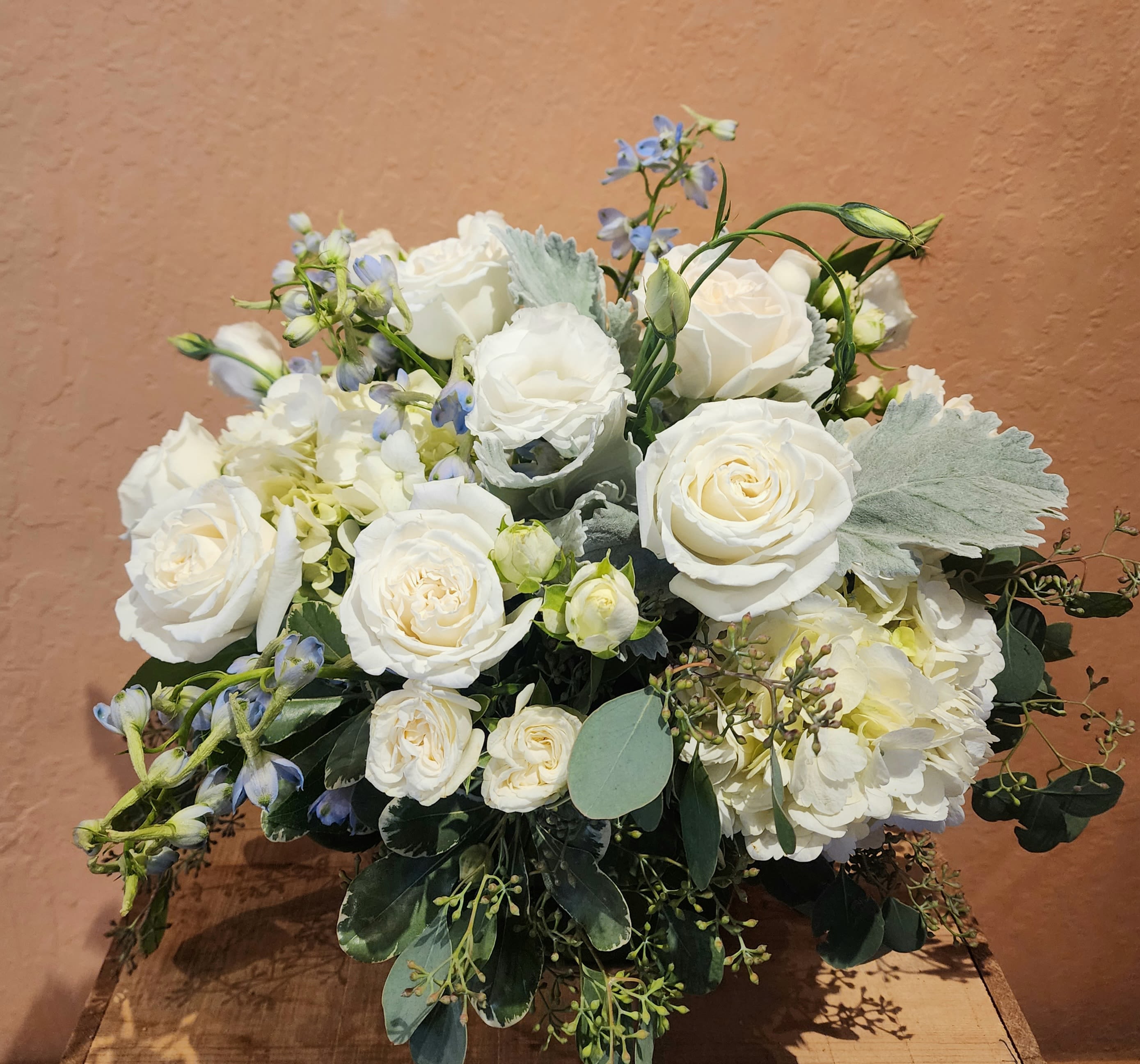 Calm Heart Calm Heart - Classic and timeless design with lush hydrangea and white roses, spray roses and blue accents. Low and full shape.