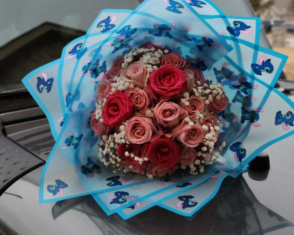 LILO & STITCH CARTOON ROSE BOUQUET  LILO & STITCH CARTOON ROSE BOUQUET  - 25 Roses—Shades of pink with added babies breath. Wrapped in LILO Stitch cartoon wrapping paper.