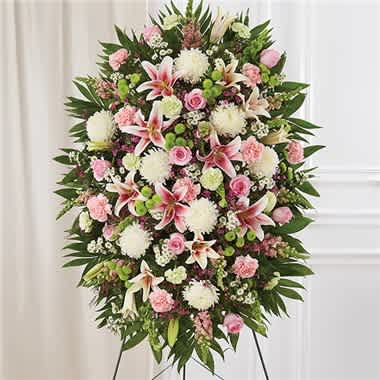 Pastel Sympathy Standing Spray - When someone passes away, it’s a chance for those who loved them to honor their life. Our impressive standing spray arrangement, meticulously handcrafted by expert local florists with peaceful pastel blooms for a lush, full presentation, creates a grand and memorable tribute. •Standing spray arrangement with pink roses, Oriental lilies, snapdragons and carnations; white football mums and monte casino; lime green carnations; green button poms; purple waxflower; Bells of Ireland; accented with soft, lush greenery •Large measures approximately 56&quot;H x 38&quot;L without stand •Medium measures approximately 46&quot;H x 34&quot;L without stand •Small measures approximately 42&quot;H x 30&quot;L without stand •Arrives on an easel •Appropriate for the funeral home or gravesite •Our florists hand-design each arrangement, so colors and varieties may vary due to local availability