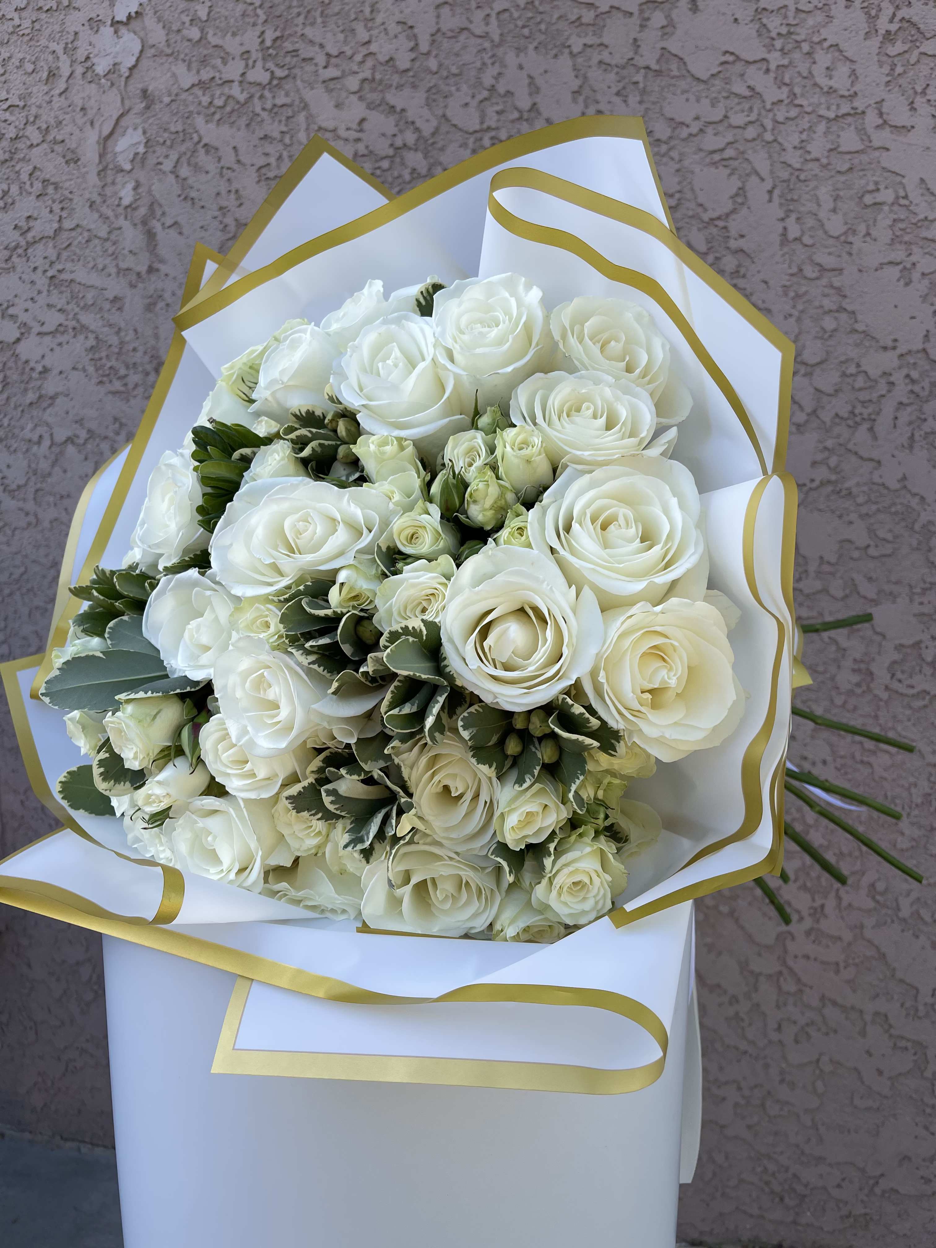 Ivory Grace - Classic and serene, Ivory Grace is a luxurious bouquet of white roses and cream spray roses, elegantly wrapped in white and gold. Designed in Beverly Hills, CA and available for same-day delivery across Los Angeles, this arrangement is a symbol of pure love, new beginnings, and heartfelt sympathy. Handcrafted by Family Tree Flower, your trusted Beverly Hills florist, this bouquet is perfect for weddings, anniversaries, or sending a message of grace and peace throughout the LA area.  White Roses – Purity, innocence, reverence, and new beginnings. White Spray Roses – Charm, appreciation, and thoughtfulness.