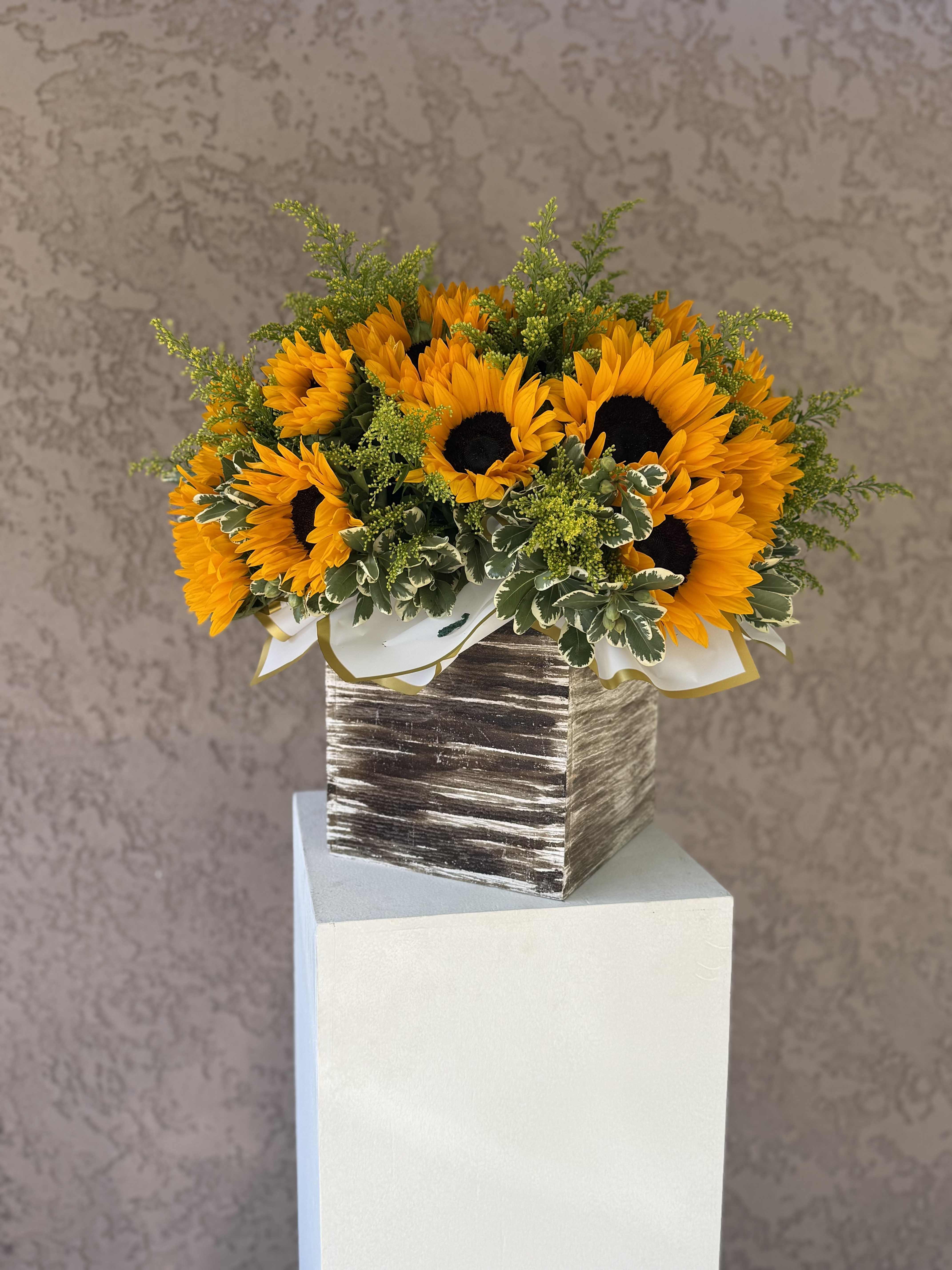Box of Sunlit Joy - Bring warmth and happiness into any space with Box of Sunlit Joy, a vibrant sunflower arrangement presented in a modern textured box. Designed in Beverly Hills, CA and available for delivery throughout Los Angeles, this sunny bouquet is ideal for celebrations, birthdays, thank-you gifts, or a cheerful pick-me-up. Handcrafted with care by Family Tree Flower, your local Beverly Hills florist offering premium, same-day floral delivery across LA.  Sunflowers – Positivity, adoration, loyalty, and strength Solidago (Goldenrod) – Encouragement, happiness, and good fortune Variegated Pittosporum – Balance, protection, and natural harmony