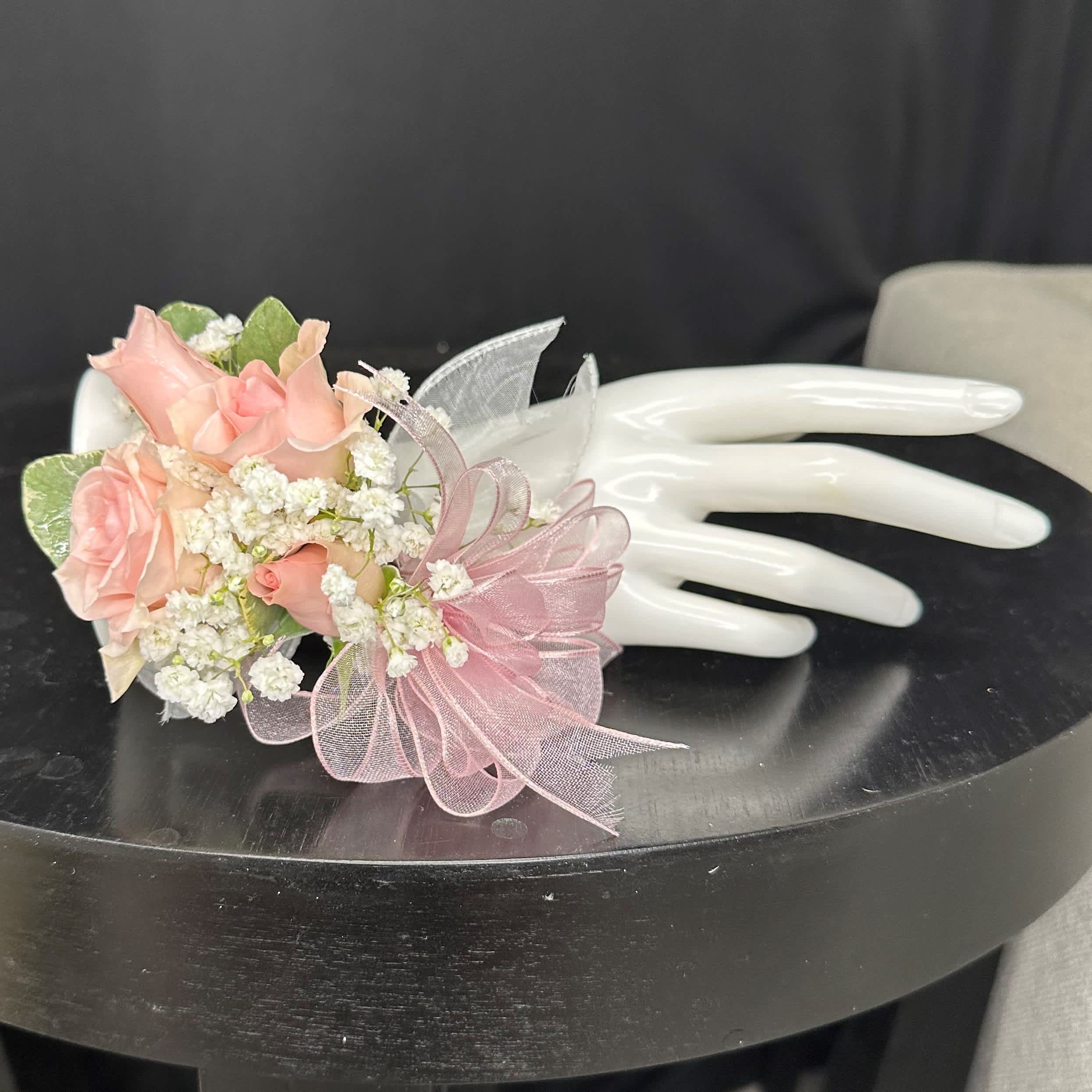 Pink Rose Corsage - Create a stunning accent for your special occasion with this exquisite pink rose corsage. Utilize the special instructions to select the perfect ribbon color, allowing you to customize this accessory to match your desired aesthetic or event theme. Whether you opt for a classic ivory, a bold red, or a delicate blush pink, let the chosen ribbon complement the elegance of the white rose, enhancing the beauty of your ensemble with a personal touch.