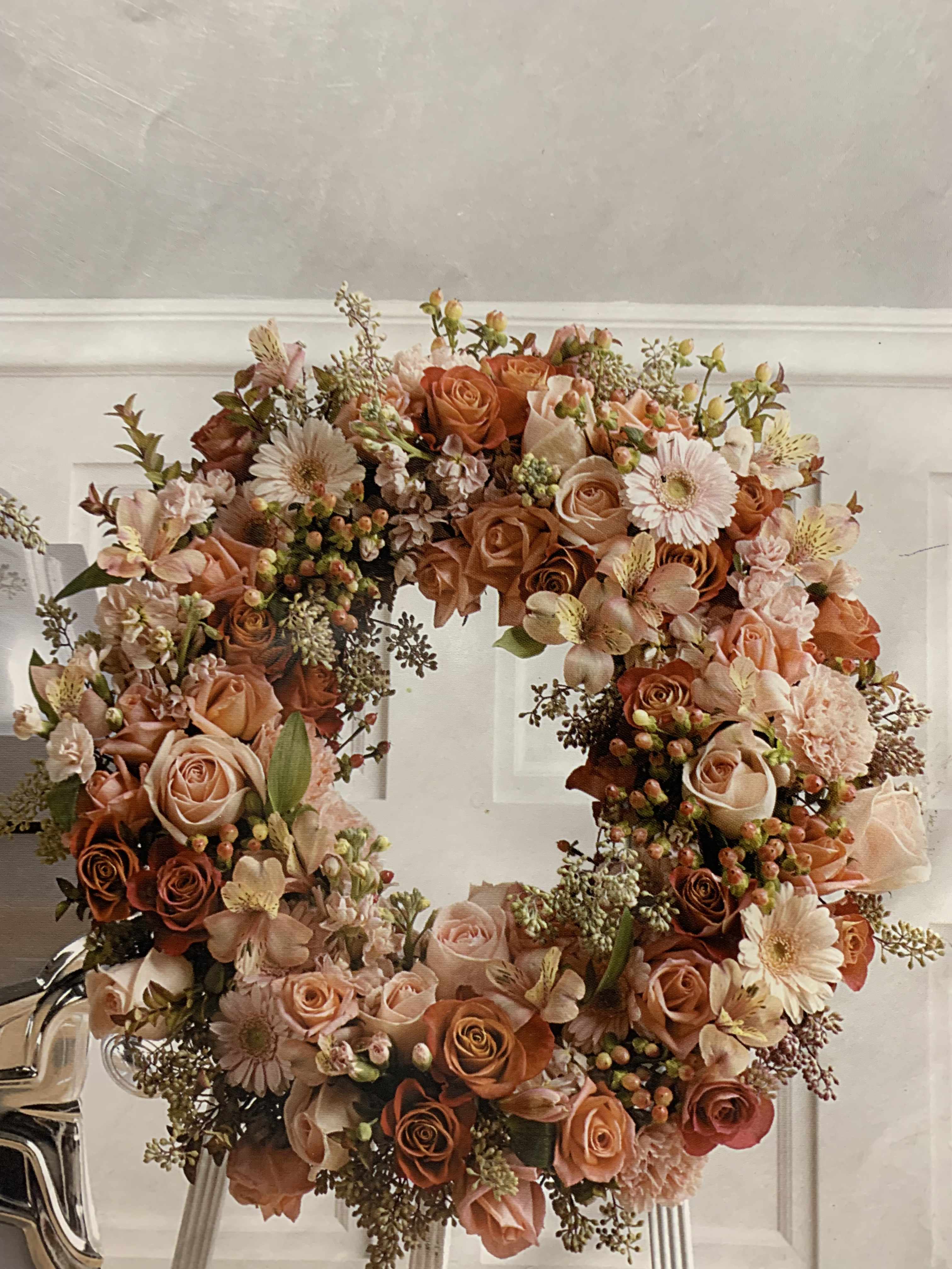 Peach Blooms of Sympathy Peach Blooms of Sympathy - This Wreath is filled with a variety of tones of peach, orange and greens to create the perfect blend of flowers to show your sympathy and love.