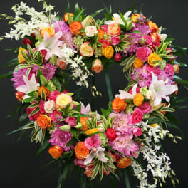 Spirited Heart of Love Wreath With Roses, Lilies & Orchids Spirited Heart of Love Wreath With Roses, Lilies & Orchids - This open heart beauty is expressing the spirit of your loved one through this assortment of white, orange, and pink florals in a heart-shaped wreath. May include roses, lilies, dendrobium orchids, dahlias, hydrangea and mixed greens.