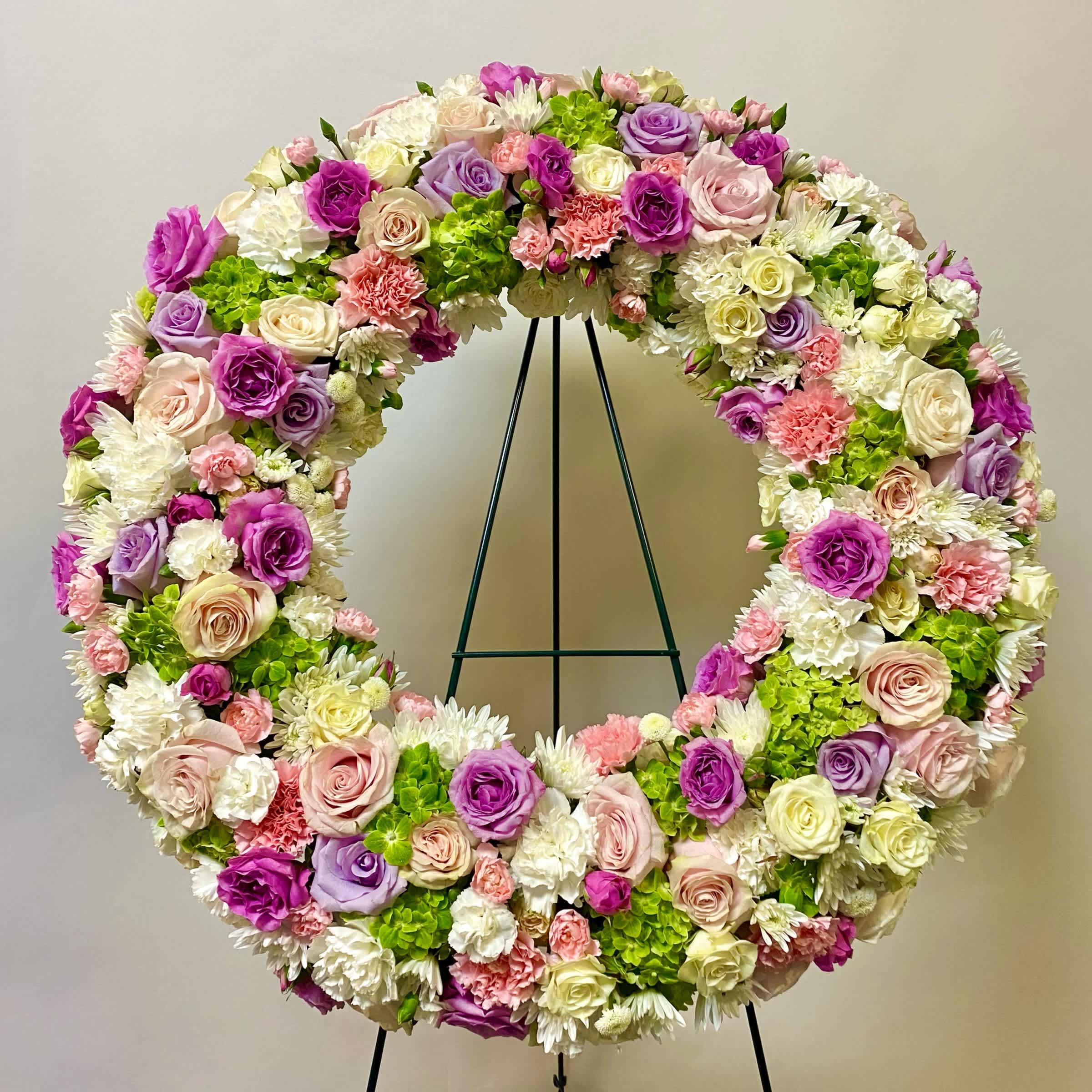 Field of Wishes Wreath - This Standing Wreath Includes White roses, Light Pink Roses, Lavender Roses, Green Hydrangeas, White Spray Roses, White Carnations, Light Pink Carnations, Mini White Carnations, Light Pink Mini Carnations and White Cushion Mums. Or as Similar as Possible.
