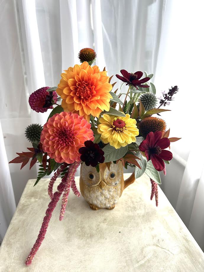 Hooo is Ready for Fall? Hooo is Ready for Fall? - A mixture of late summer and fall blooms such as dahlias, chocolate cosmos, zinnias, and amaranthus designed within a charming reusable owl mug. Would also pair well with a bag of our coffee! As always, all designs are subject to substitution based on what is available.