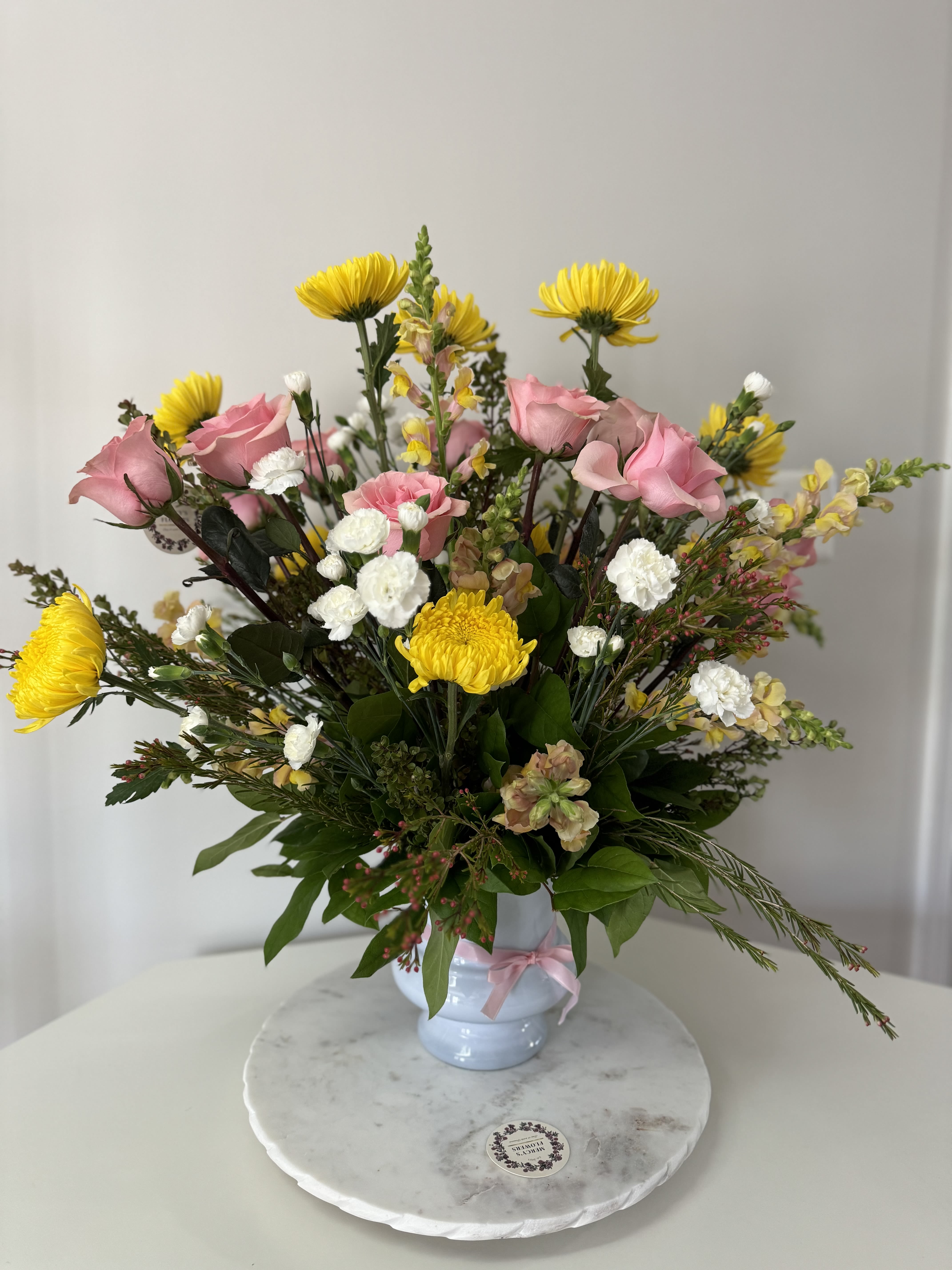 Mercy's Floral - This is an updated version of the classic pedestal arrangement ,it's a bold structured piece  the requires a large number of flowers  to create a garden.