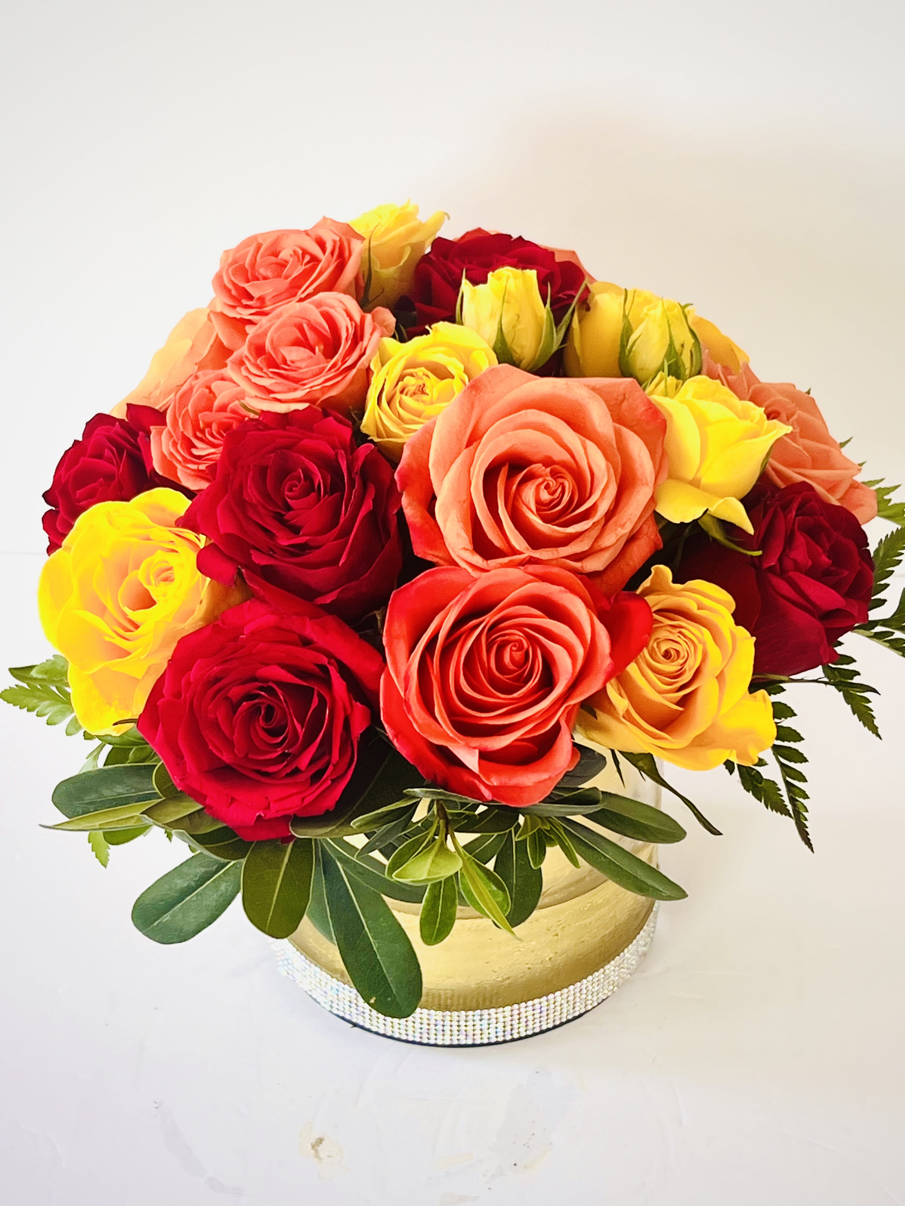 Birthday Bliss - A lively mix of red, yellow, and orange roses arranged in lush greenery, bursting with warmth, joy, and celebration. Perfect for making any birthday unforgettable.