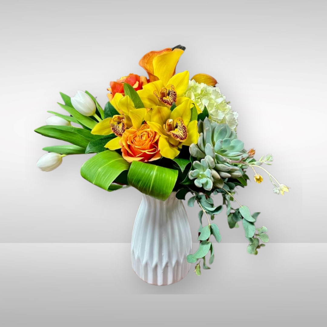 There is Beauty in Simplicity - Recipe: Orange Roses, White Hydrangae, Cymdium Orchids, White Tulips, and green succulent in a white vase. Availability: All year round Design View: Symmetric Front Facing View Photo shown: Standard 