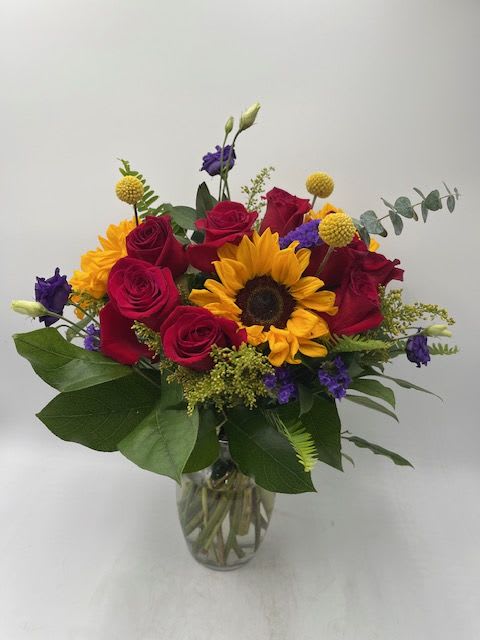 Hello Fall! Hello Fall! - Beautiful mixed bouquet of a dozen red roses, sunflowers, craspedia, purple lisianthus, purple statice and premium filler flowers and greens in a tall glass vase.