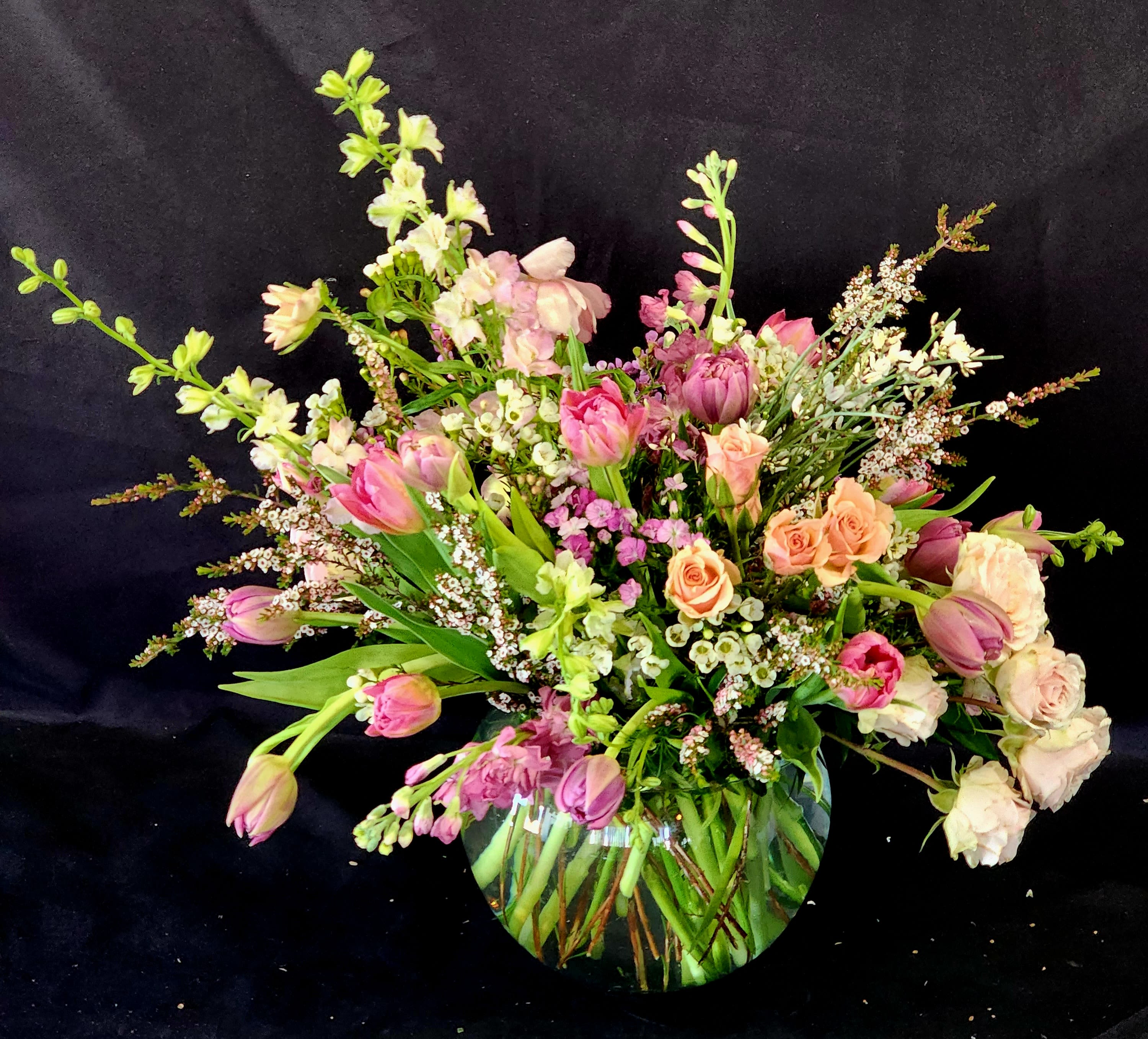 A bowl of yumminess - A bright bubble arrangement with seasonal flowers. This arrangement makes a lovely thank you or just because gift.  Deluxe contains high end flowers. Premium contains premium flowers with more blooms.
