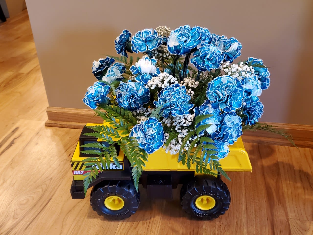 blue carnations with baby breath and greens - comes in a Tonka Truck
