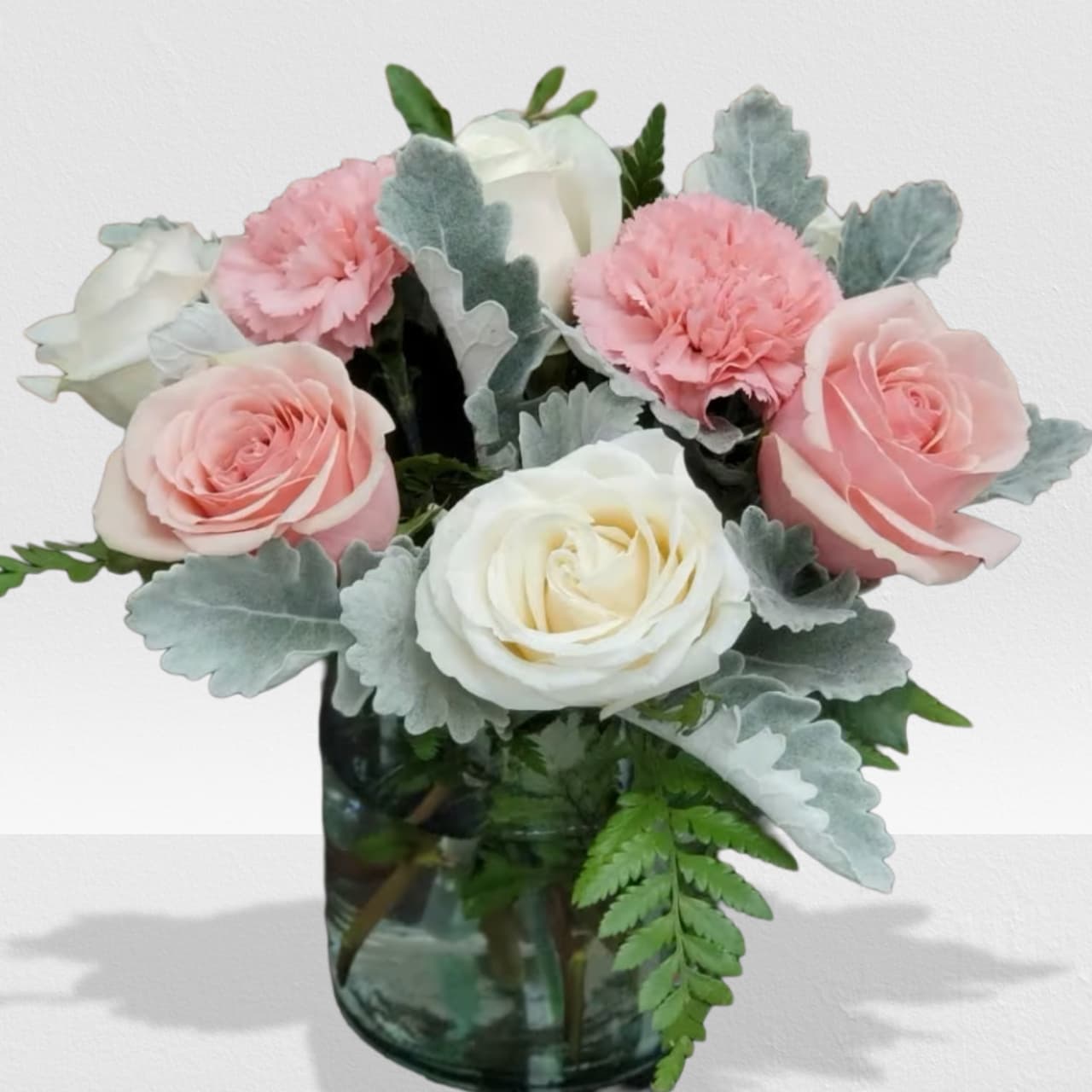 Sweet and Subtle by Manny Sweet and Subtle by Manny - This arrangement includes pink roses, white roses, white spray roses, pink carnations, and dusty miller. Sweet & Subtle by BloomNation™ is the perfect gift for a birthday, thank you, or just because. APPROXIMATE DIMENSIONS: 9" H X 10" W
