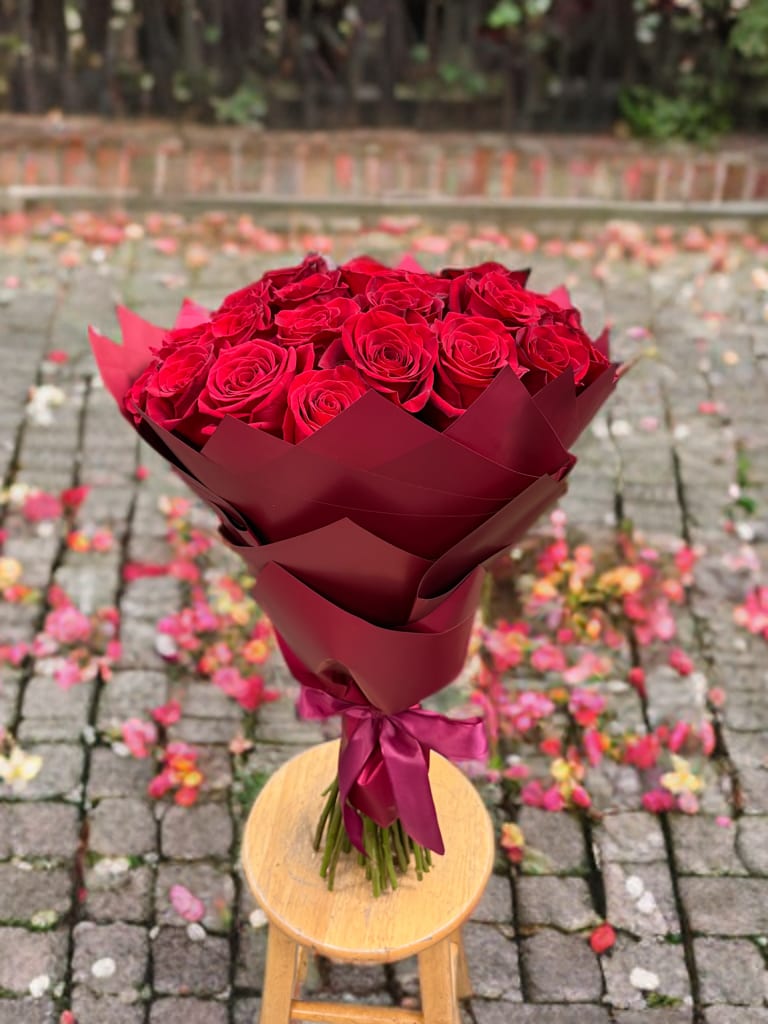 Eternal flame  - A timeless bouquet of velvety red roses, beautifully arranged in layers of deep burgundy wrapping and tied with a matching satin ribbon. This striking presentation exudes romance, passion, and sophistication, making it the perfect gift for love, celebration, or a heartfelt gesture.