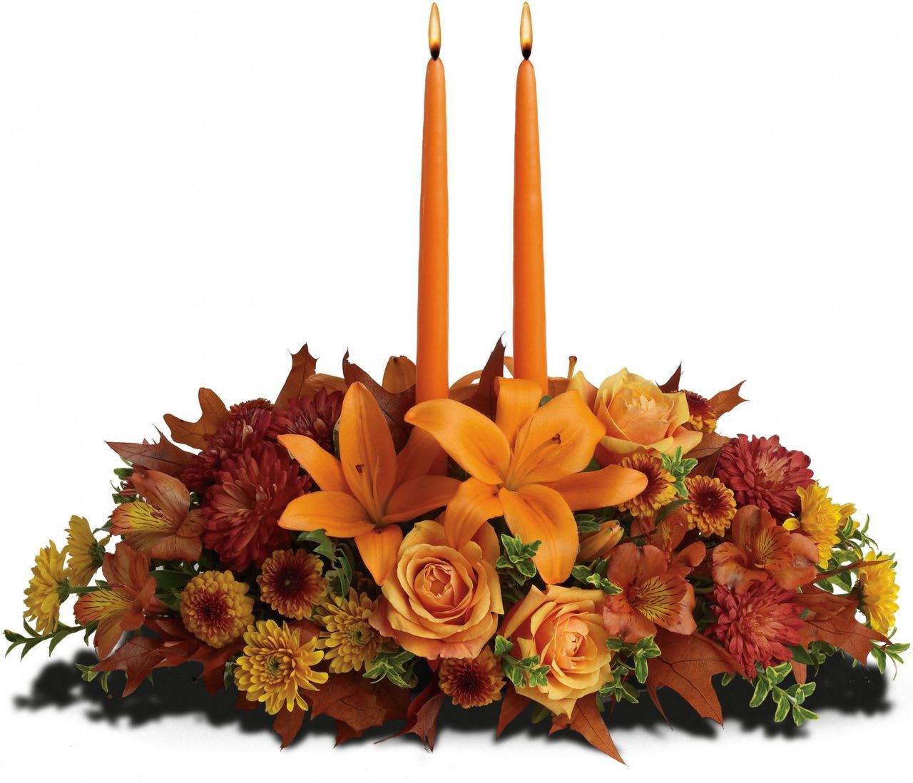 Family Gathering - Graciously gather your family around the warm glow and classic autumn colors of this stunning Thanksgiving centerpiece. A lush variety of burnt orange blooms are gathered under a pair of tall, graceful candles - perfect for decorating your Thanksgiving dinner table, entryway or hearth. Fall flowers include orange roses, orange asiatic lilies, dark orange alstroemeria, bronze button mums, yellow cushion mums, rust cushion mums, green oregonia and green huckleberry. Accented with oak leaves and two orange taper candles. Orientation: All-Around