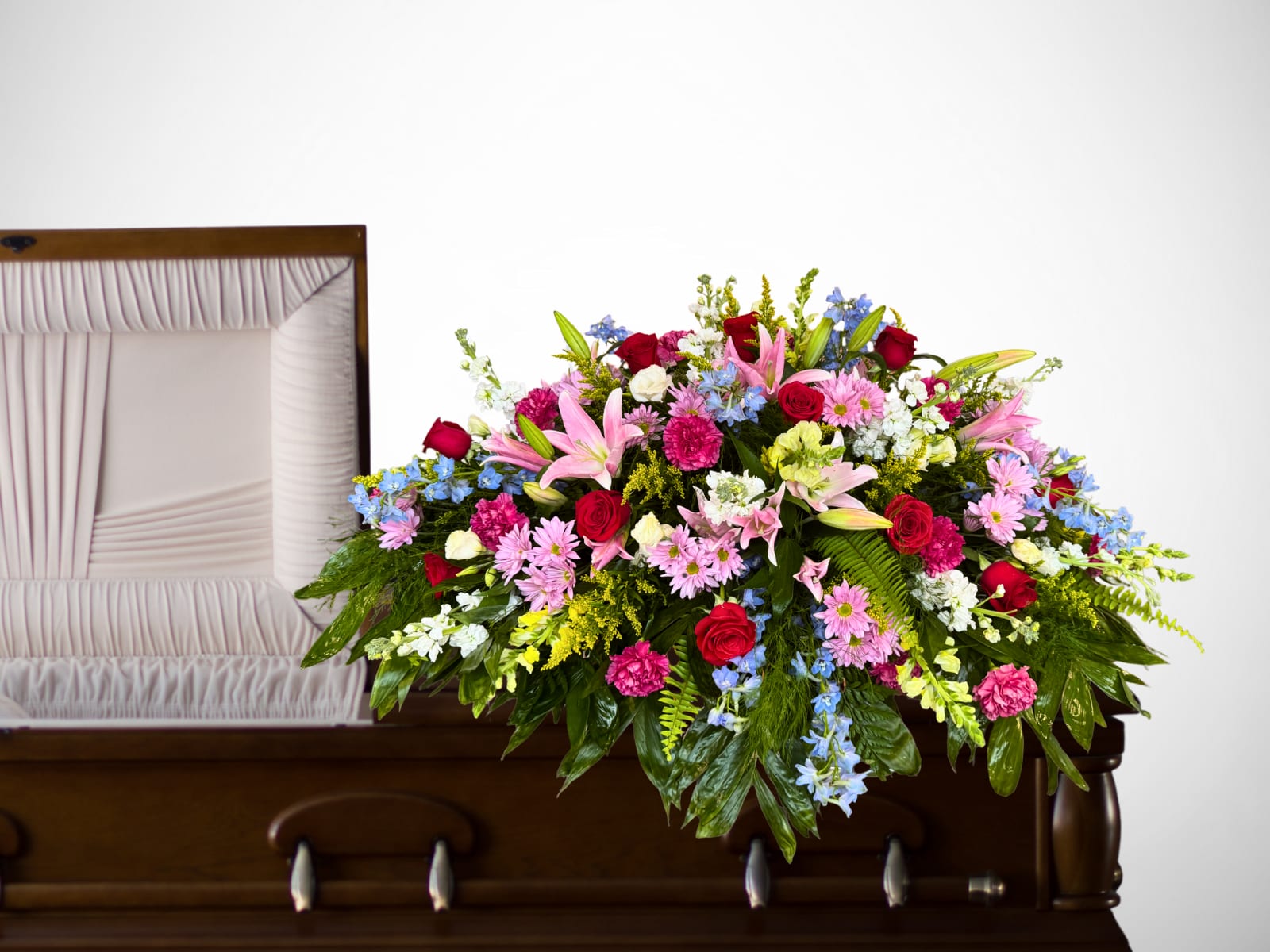 Graceful Farewell Casket Spray Graceful Farewell Casket Spray - This vibrant casket spray is a beautiful tribute, overflowing with a mix of fresh blooms in soft pastels and bold hues. Featuring elegant pink lilies, classic red roses, cheerful daisies, carnations, and delicate blue delphinium, stock, solidago, it is thoughtfully arranged with lush greenery to create a comforting display of love and remembrance. Perfect for honoring a cherished life, this spray offers a message of peace, beauty, and heartfelt sympathy.