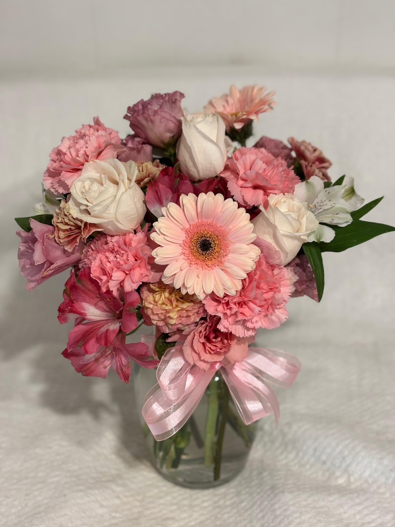 Pretty Pink and White Flower Arrangement - An Arrangement in a Vase that features roses and carnations and alstroemeria and other flowers and greenery and will bring joy to to one who receives it!