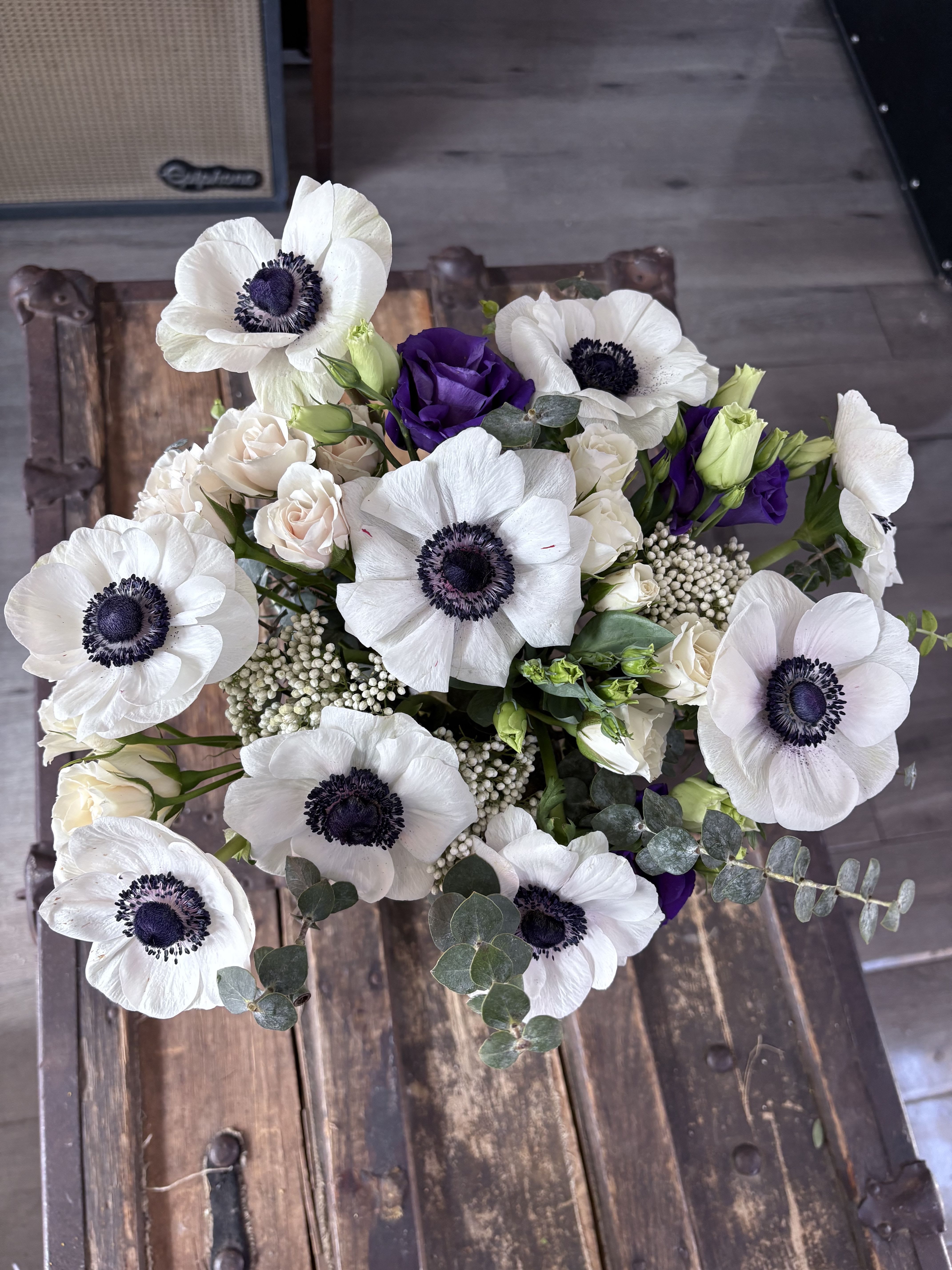  Elegant Anemones - This exquisite arrangement features striking anemones alongside lush textures of eucalyptus and seasonal blooms, creating a stunning centerpiece that captures attention and adds a magical touch to any occasion.   This design is available from Monday to Saturday until2:30 pm (In case of same day orders)