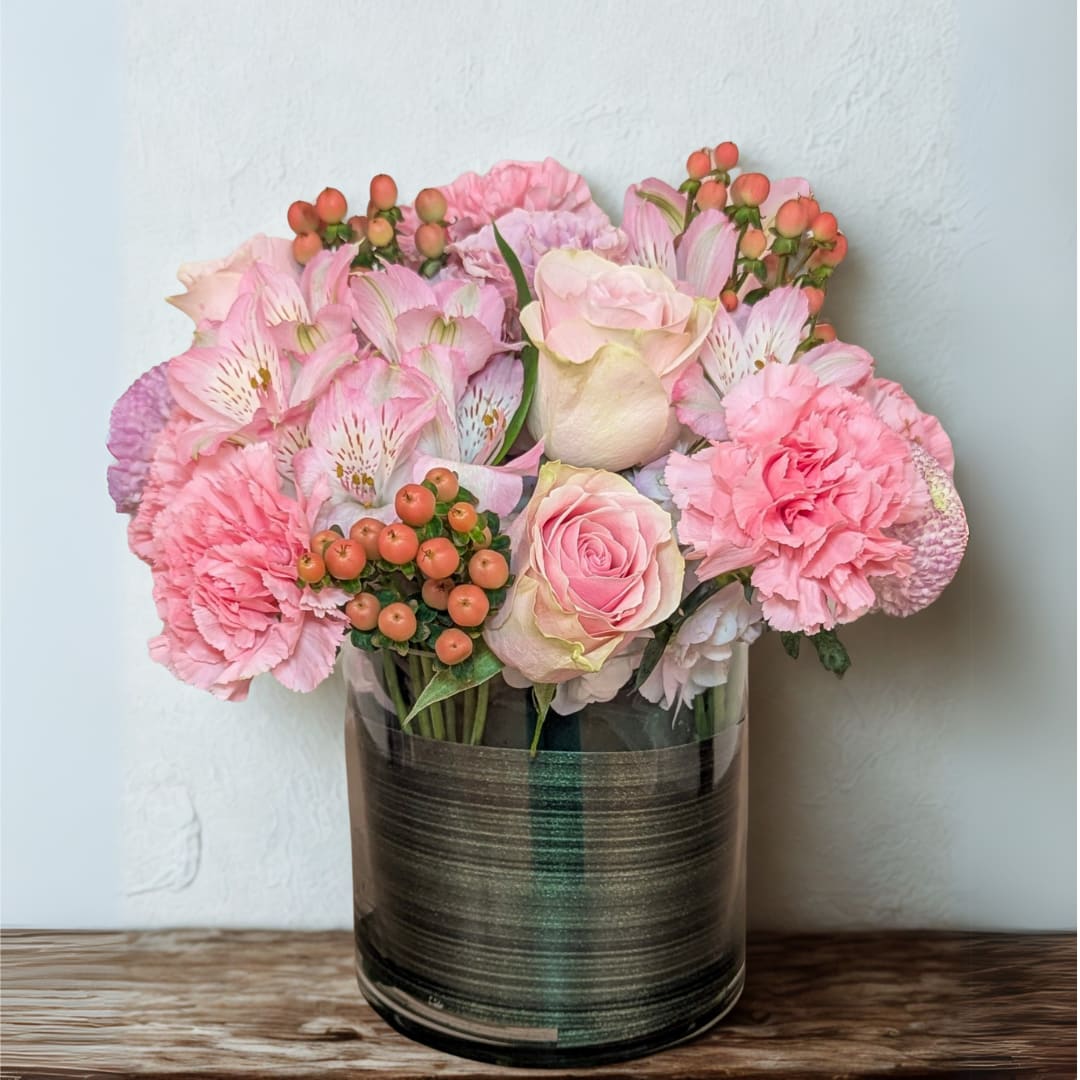 Pink Harmony - A sweet blend of roses, carnations, alstroemeria, and hypericum berries in soft pink tones, designed in a modern glass vase. This arrangement radiates charm and warmth—perfect for celebrating love, friendship, or simply brightening someone’s day.