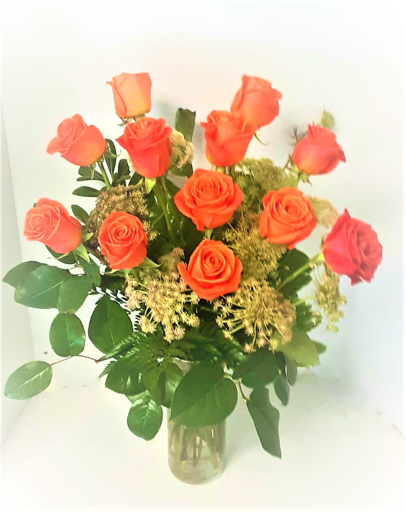 Orange Crush Roses Arrangement Orange Crush Roses Arrangement - One dozen bright orange roses arranged in a clear vase .Greenery and fillers may vary