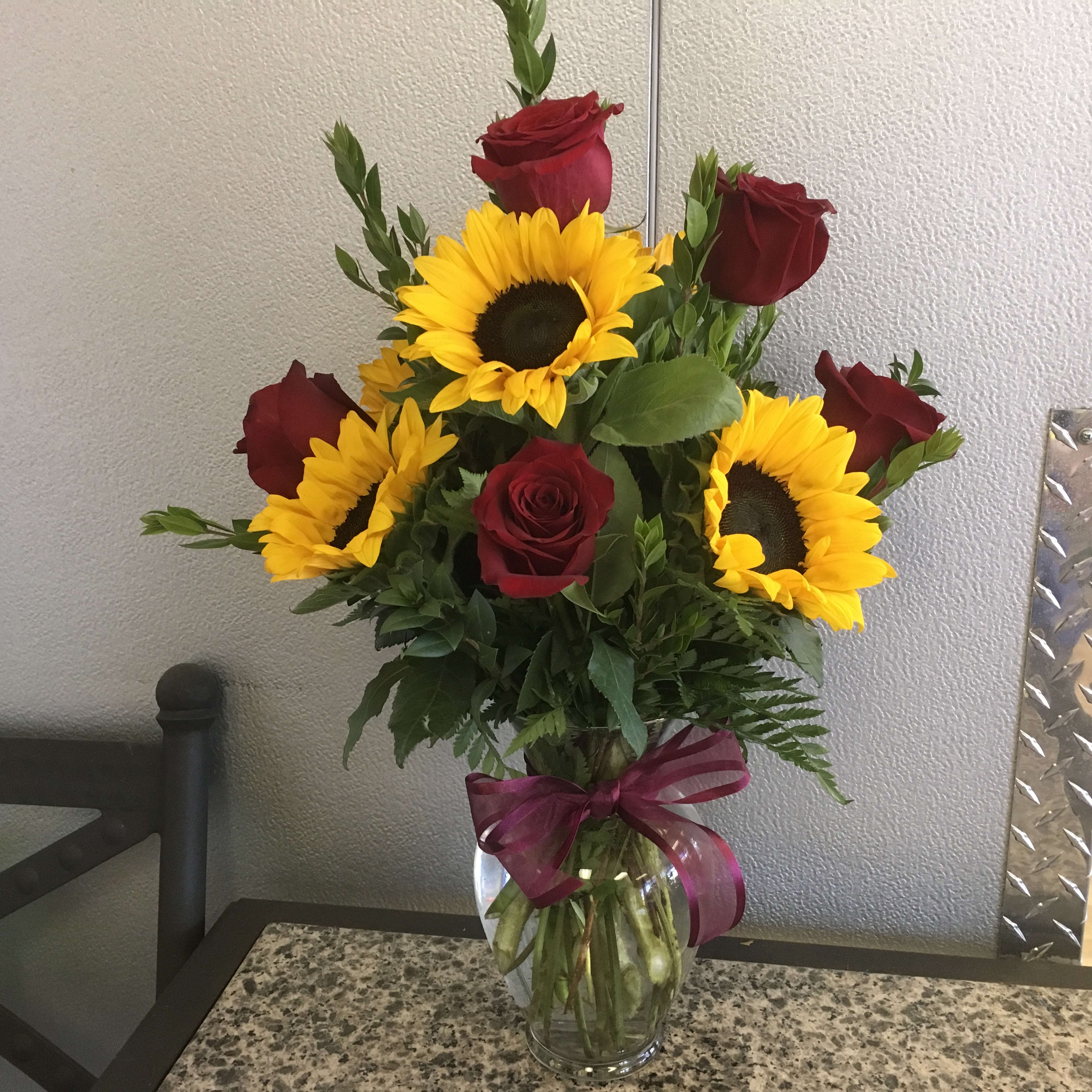 Sunny Day Roses Sunny Day Roses - 6 red roses & 3 sunflowers arranged in glass vase - Approx. height 20"
