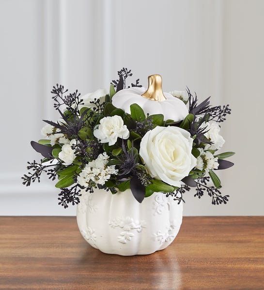 Spooky Pumpkin Bouquet - Spooky meets sophisticated in our Halloween-inspired bouquet that’s unlike any other. Black-tinted thistle and eucalyptus create a dramatic effect against bright white roses and mini carnations. Gathered in our modern-style pumpkin, with a white satin finish and golden accents, it’s an original and elegant design perfect for setting an autumn mood.  All-around arrangement with white roses, mini carnations and statice, black-tinted thistle and seeded eucalyptus; accented with assorted greenery Artistically designed in our exclusive grateful white pumpkin, a modern-styled white satin finish container with lid, featuring embossed detail and golden accents; this unique design that can be used for fresh flowers, wrapped candies or as a seasonal décor piece; measures 4.8&quot;H x 4.8&quot;W Large arrangement measures approximately 9&quot;H x 7&quot;W Medium arrangement measures approximately 8&quot;H x 6.5&quot;W Small arrangement measures approximately 7&quot;H x 6&quot;W Our florists hand-design each arrangement, so colors and varieties may vary due to local availability
