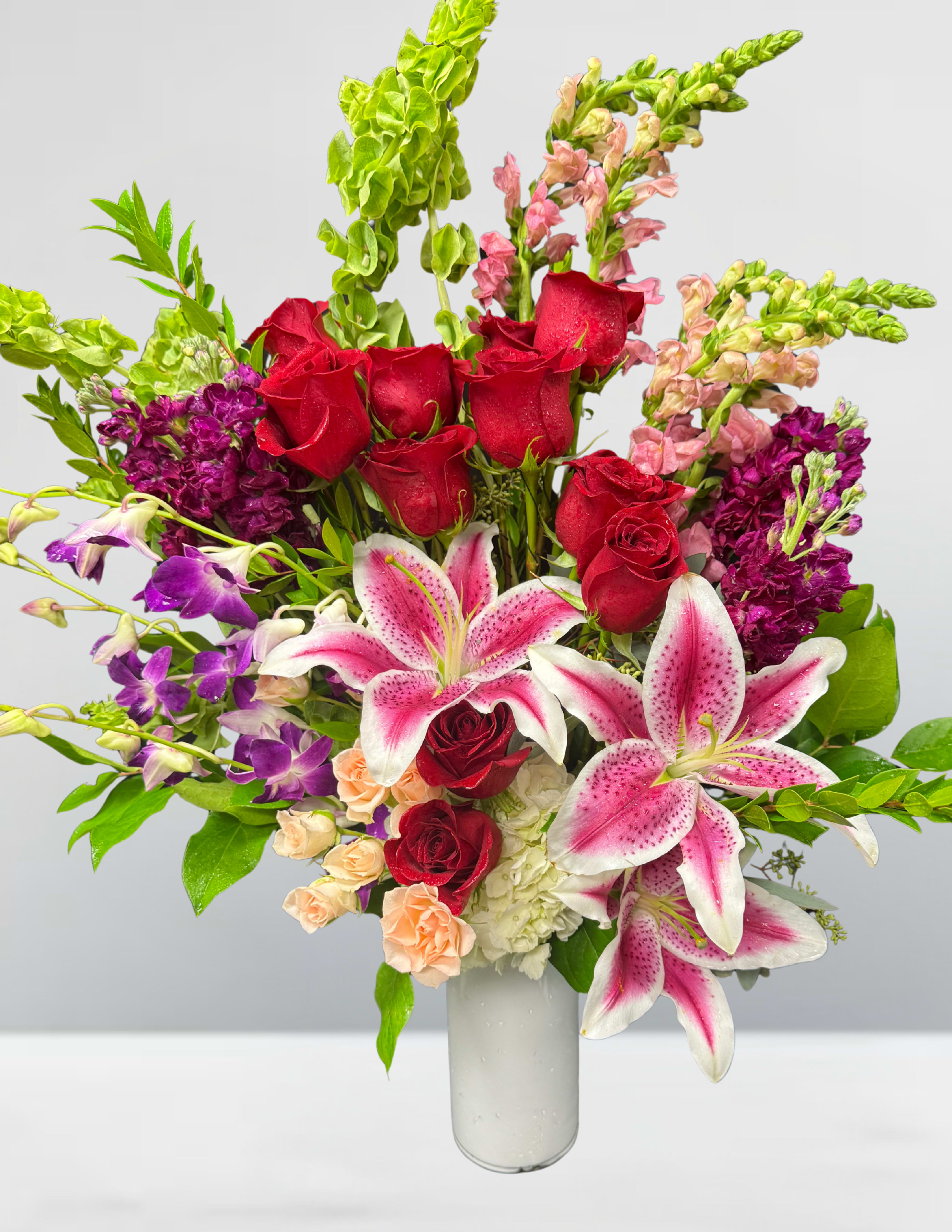 The painted garden The painted garden - The Painted Garden A living canvas of color and texture, this arrangement blends the drama of crimson roses, the softness of blush lilies, and the exotic flair of purple orchids. Snapdragons and Bells of Ireland rise like brushstrokes of vertical elegance, while lush greenery adds depth and movement. Each bloom plays its part in a symphony of hues—romantic reds, playful pinks, regal purples, and verdant greens—creating a bouquet that feels like a masterpiece in motion. Perfect for moments that deserve more than beauty—moments that deserve art.