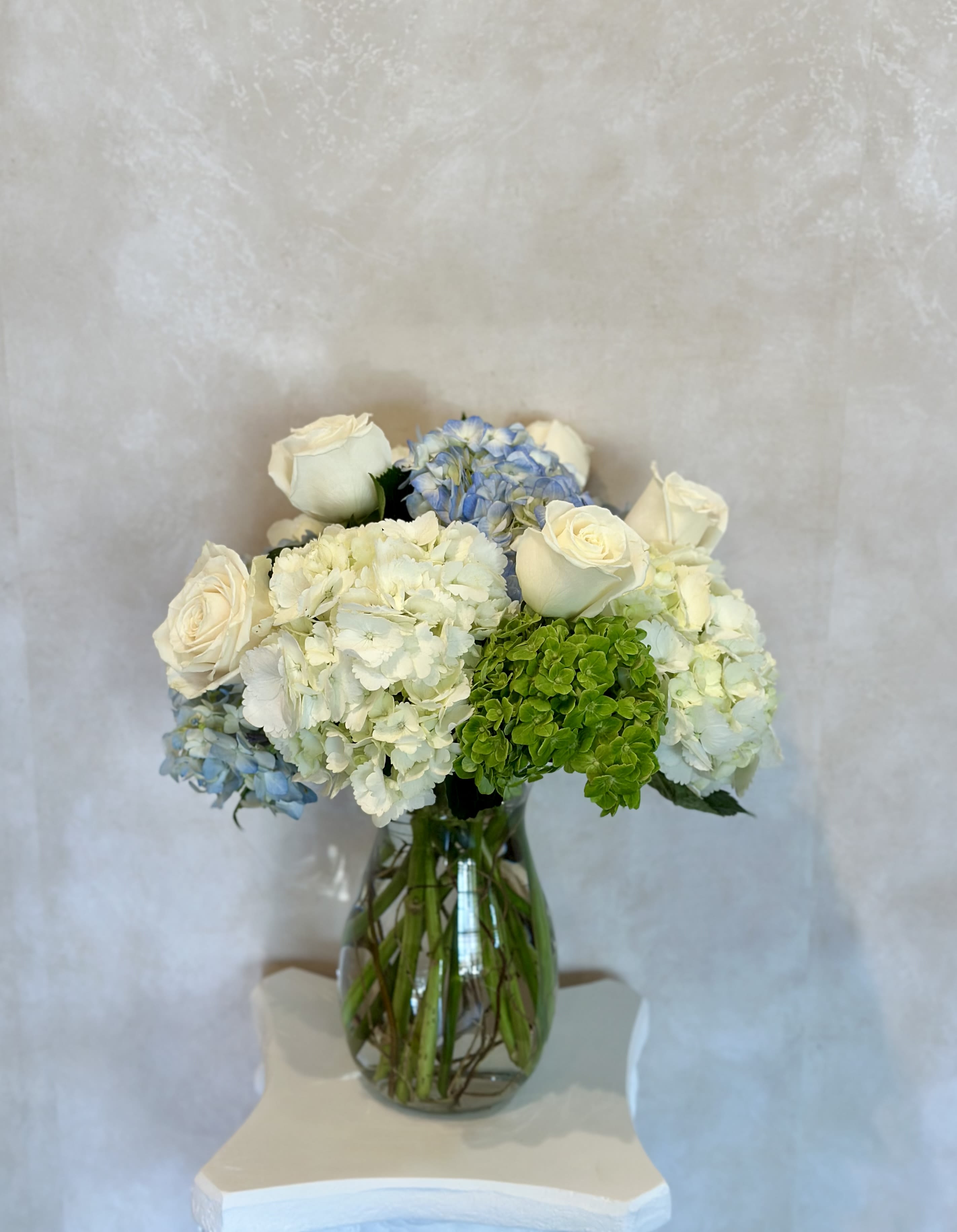 Clear Skies  - Mix of white, blue and green hydrangeas. 5 white roses and curly willow 
