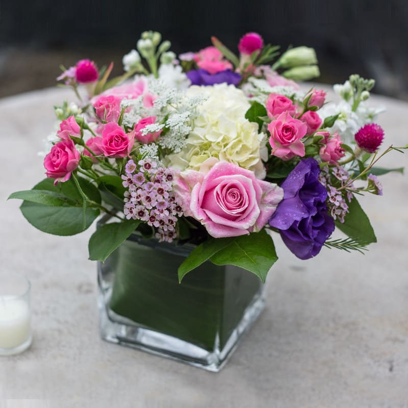 Girly Mix - White hydrangeas, wax flower, spray roses, gumfrina, purple lisianthus, lemon leaf, and pink rosita vendella roses comprise this arrangement your daughter or wife will adore! 