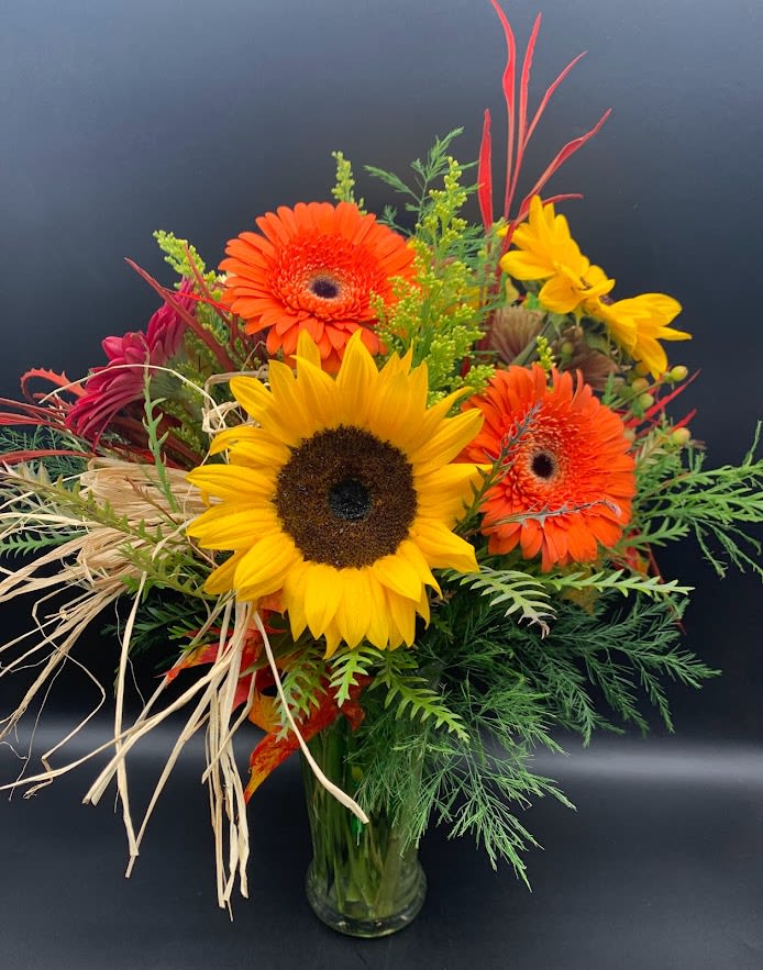 BELLA'S SWEET BOUQUET $85/115/145 - Simple flowers with a vibrant twist.  Gerbera daisies and Sunflowers with garden accents. Our deluxe and premium versions will add additional flowers to value.  PS: Don't forget to add a candle and some chocolates. 