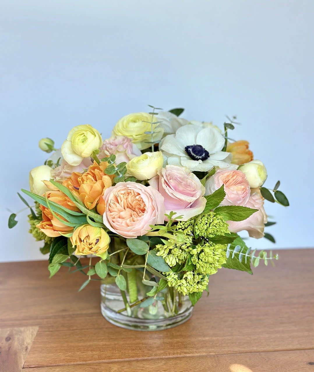 Magic Beauty - Vase size is 5&quot;x5&quot; - including all premium flowers. This sweet arrangement features green hydrangea, light pink roses, peach garden roses, peach ranunculus, white anemone, yellow or orange tulips, and eucalyptus,  Delivered in a glass cylinder vase. Vase: