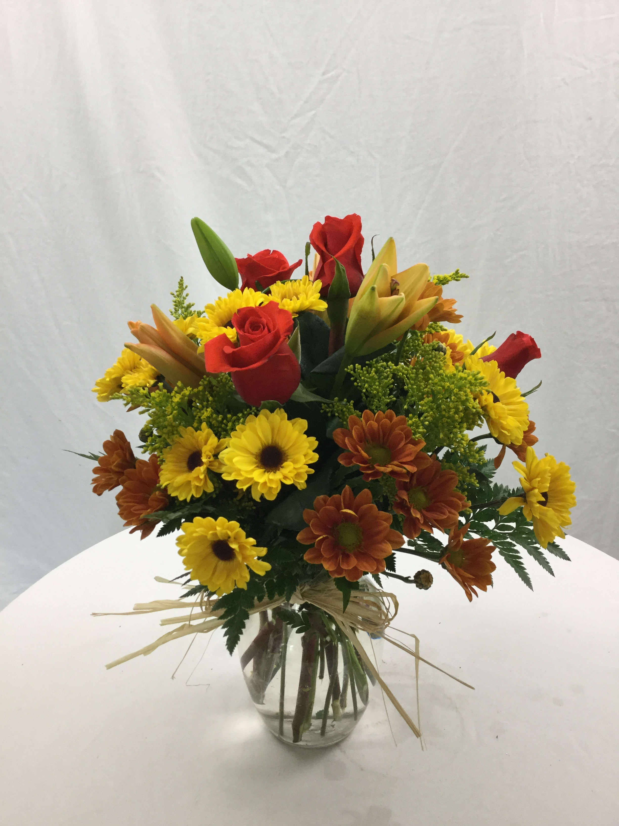 Thinking of You Bouquet - A beautiful mix of fresh Autumn blooms handcrafted and designed in a clear glass vase. Includes raffia and fresh greenery. Makes for a wonderful gift through the Autumn and Winter months. Please note: Lilies may come in bud form, as we get daily fresh blooms delivered every single day.