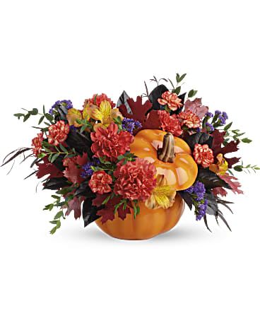 Teleflora's Hauntingly Pretty Pumpkin Bouquet - Add a hauntingly beautiful touch to your fall festivities with this magnificent mix of autumnal alstroemeria and carnations, gathered in a glazed ceramic pumpkin that's sure to be an annual décor favorite! This bouquet features orange alstroemeria, dark orange carnations, miniature orange carnation, purple sinuata statice, parvifolia eucalyptus, red agonis, and lemon leaf. Delivered in Teleflora's Trick &amp; Treat Pumpkin. Orientation: All-Around