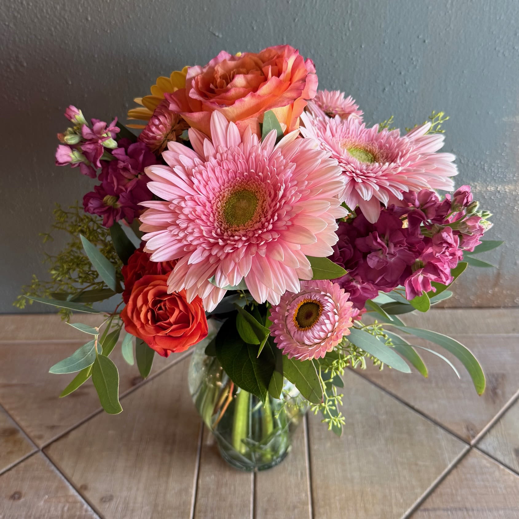 Sunset Serenade - Capturing the magical colors of a beautiful sunset, this arrangement is cheerful, radiant and unforgettable!