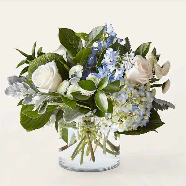 Clear Skies Bouquet - Let this uplifting arrangement be reminders of the clear skies ahead. Capturing the feeling of hope that a new day brings, this bouquet is composed of voluminous hydrangea blooms and vibrant belladonna delphinium to refresh their mood.  Details 15&quot; H x 18&quot; W  Bloom Details Delphinium Hydrangea Rose