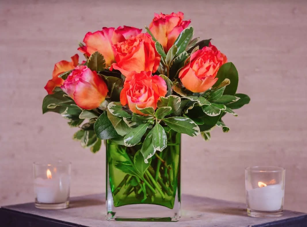 Simply Roses - A dozen beautiful roses set in a cube vase with lush greens.  Please specify color requests in Special Instructions. If no color is specified, we will use a color closest to the picture and the freshest blooms. Deluxe includes 18 roses. Premium includes 24 roses. ***Due to shifts in our supply chain we may substitute a another cube vase in various colors, or a clear cube vase-If you have a request please let us know in the special instructions upon ordering***