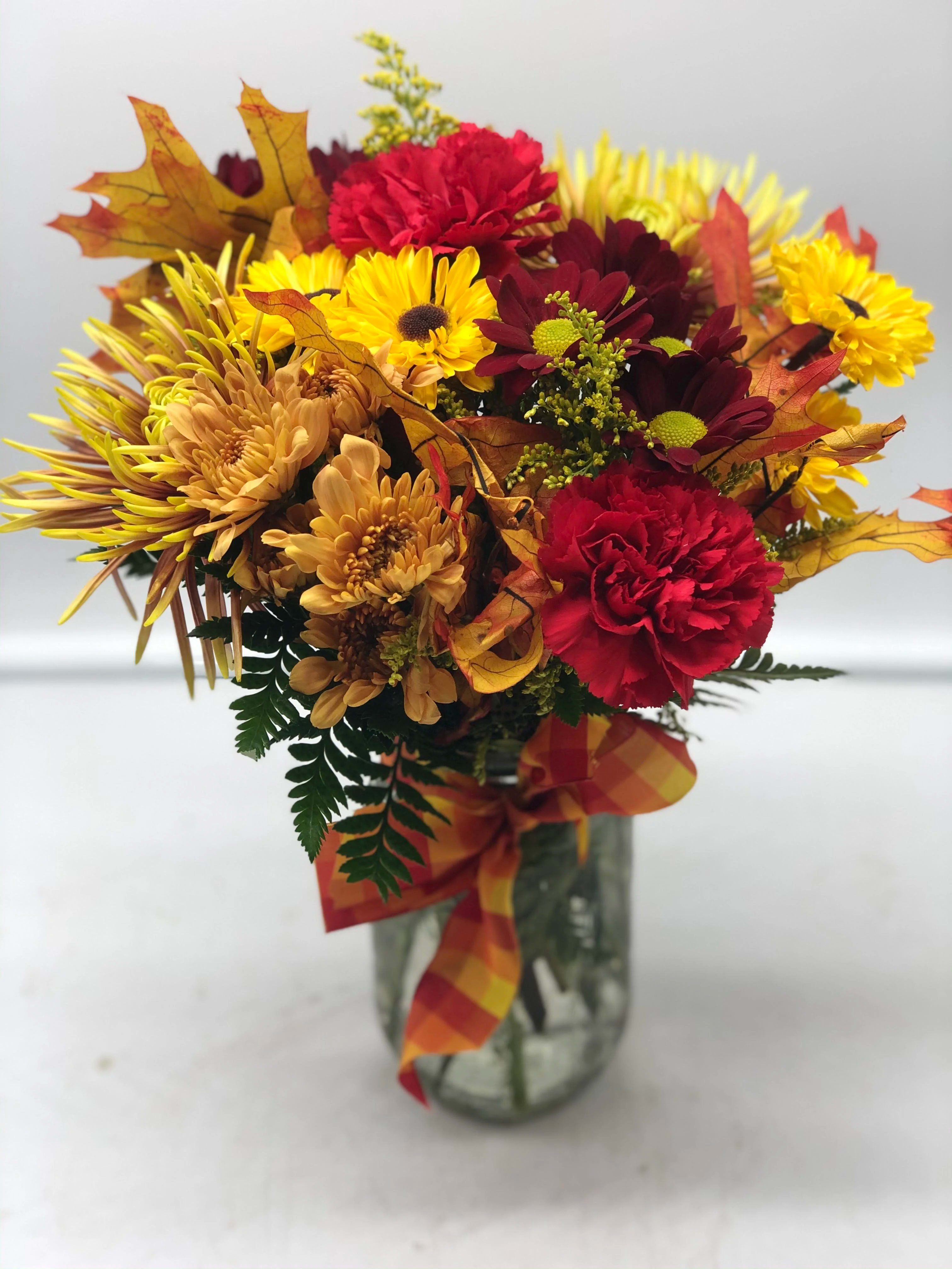Mason Jar of Mums - A beautiful fall mix of mums arranged in a mason jar adorned with a seasonal bow!