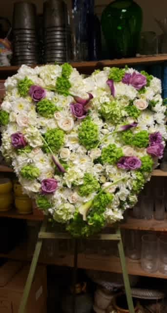 Heartfelt sympathy - A full heart standing spray made with a collection of roses, calla lilies and stylized accents appropriate for a sympathy tribute. 
