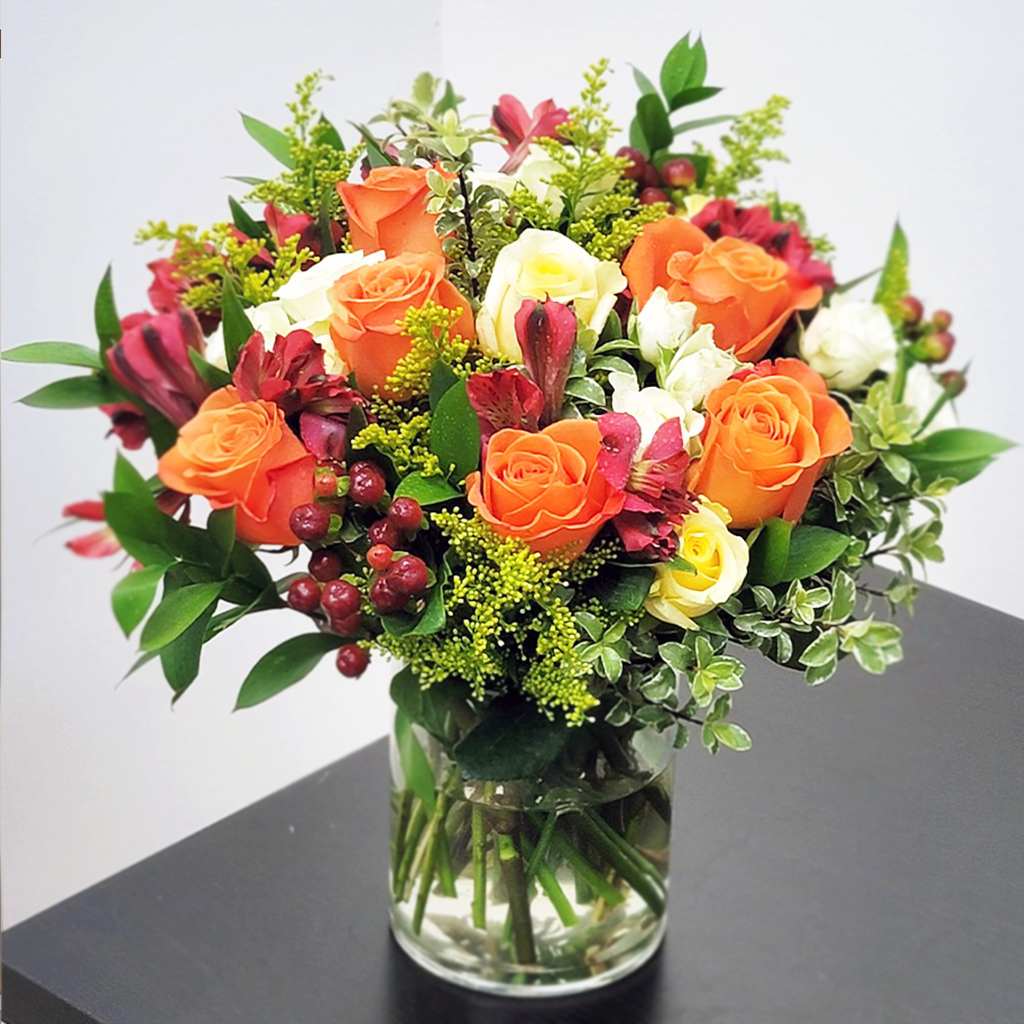 Amazing Blooms (BN Exclusive) - Amazing blooms flower bouquet of yellow and orange roses,  including purple mini carnation, delivered in a glass vase. A perfect gift for  Mother's Day, Thank you, Just Because, or any other occasion.  APPROXIMATE SIZE: 18&quot; H x 15&quot; W. The standard bouquet includes 15 stems. Deluxe bouquet includes 20 stems. Premium bouquet includes 25 stems.