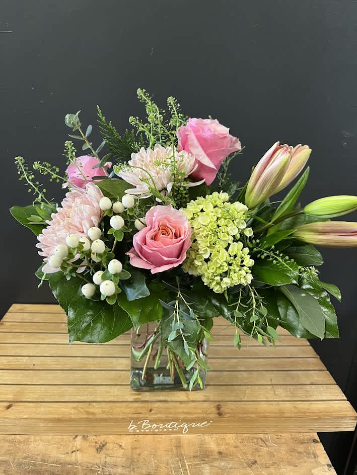 The Flamingo - Turn heads with our Flamingo Bouquet, a daring mix of flamingo roses, lush hydrangea, delicate lilies, and creamy cremones. Vibrant, sophisticated, and unforgettable—perfect for the modern, trend-savvy gift-giver.  This is a one-sided arrangement.  *Some stages of flower life may vary. (Example: Lilies may be more open than imaged.)  Flower shortages and product availability means that some substitutions will apply. Value will always be filled. This bouquet might include eucalyptus amongst the greenery. It may be toxic to pets including but not limited to Cats and Dogs if digested.