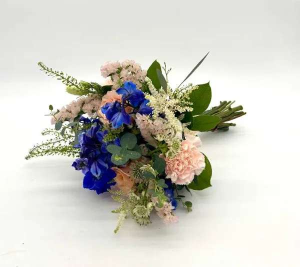 Peach and Blue Nosegay - Garden look with a variety of fresh peach and blue florals. When ordering please specify your choice of satin ribbon color under special instructions or it will be wrapped in a neutral color. Designers may need to implement substitutions, however will follow the general arrangement style and color theme. Standard price point is pictured.