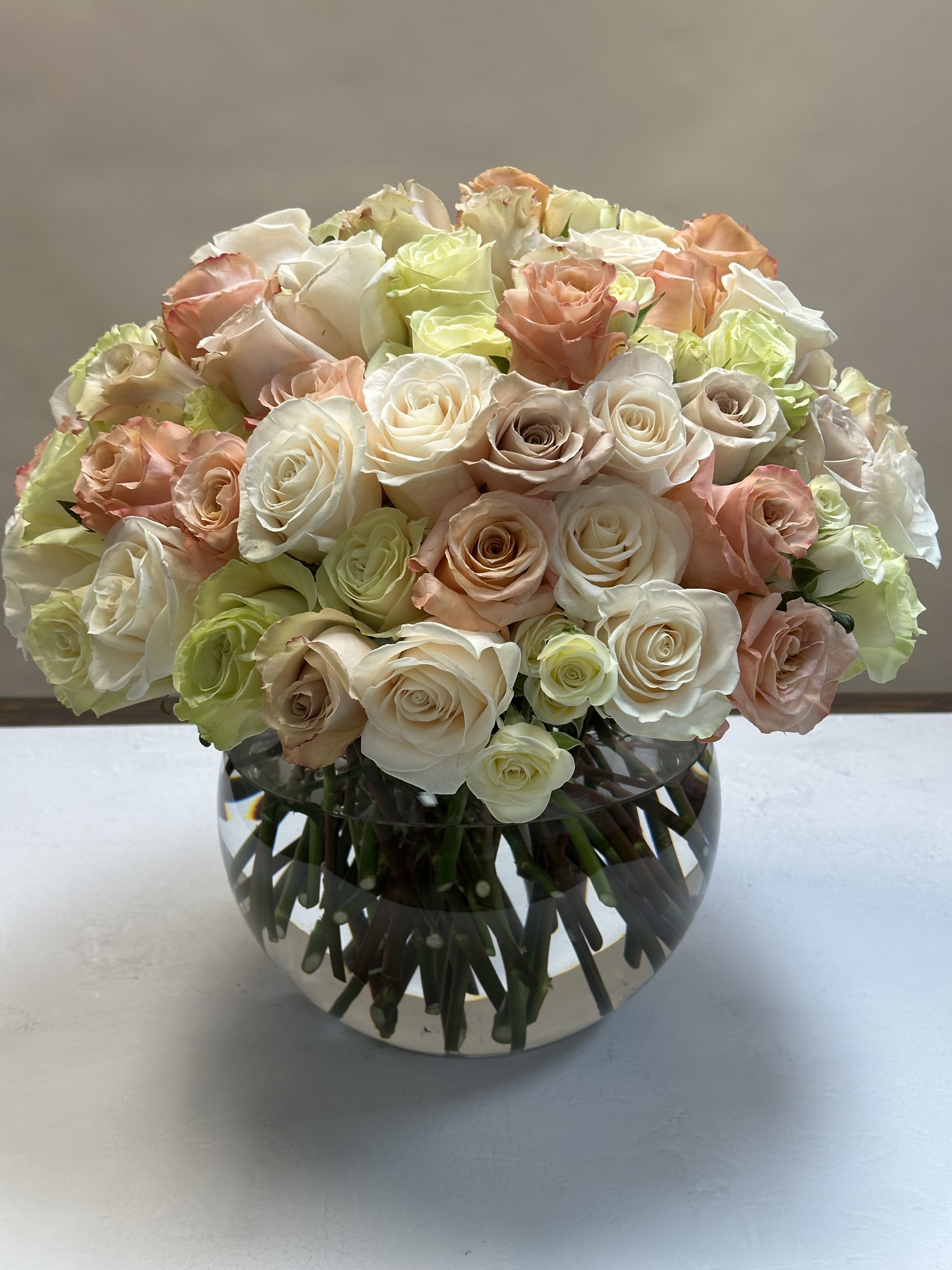 Blush Elegance - A beautiful mix of pastel roses, arranged in a tight and modern style. Elegant and timeless, this design is the perfect gift for your loved ones. Available in three sizes: Standard -55 roses, Deluxe - 75 roses, and Premium - 101 roses.