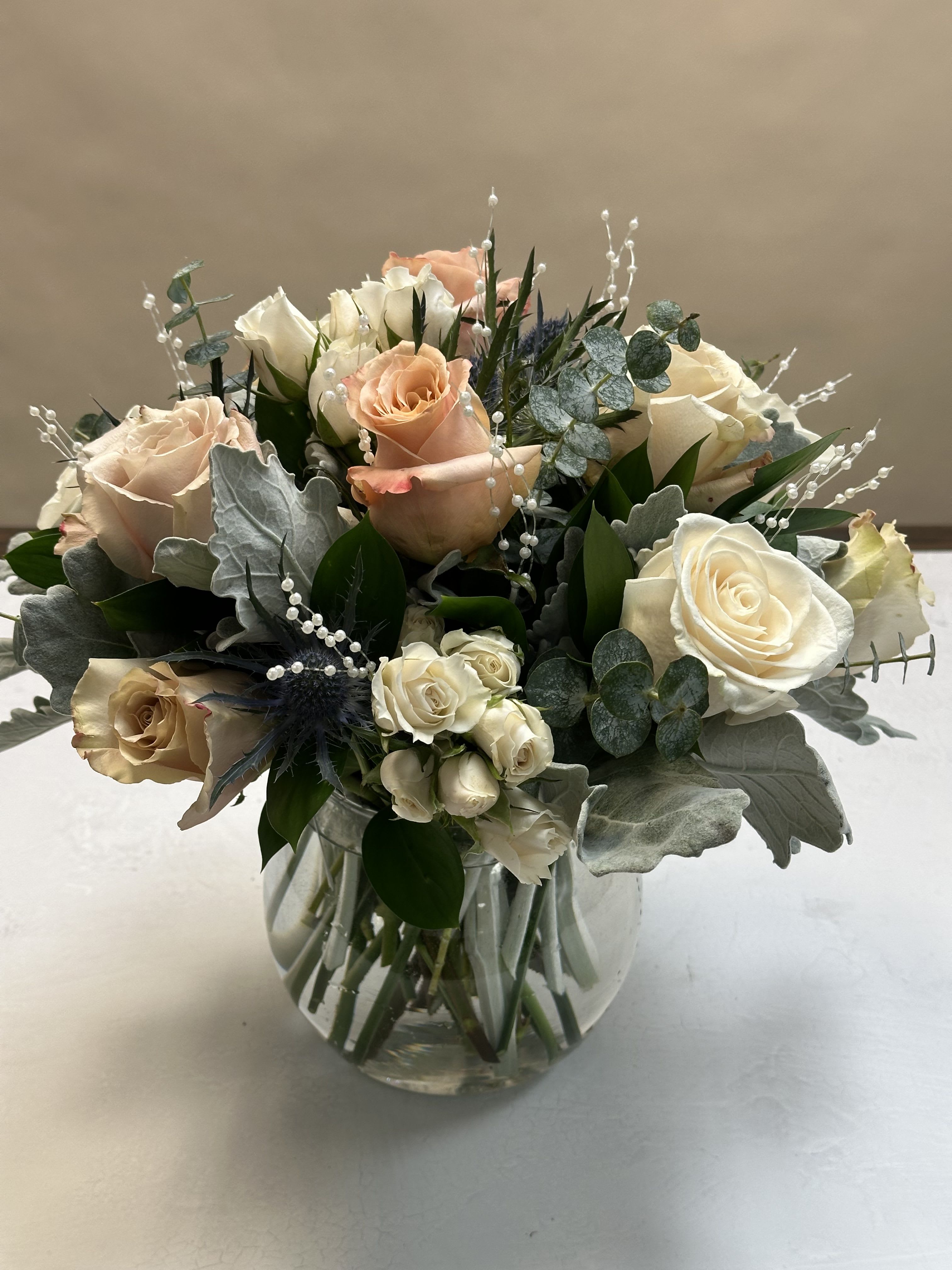 Nude Mood - A chic and timeless design, perfect for any occasion. Featuring elegant white and Beige roses, delicate white spray roses, and a fresh mix of greenery, this arrangement brings a soft, natural beauty to every setting.