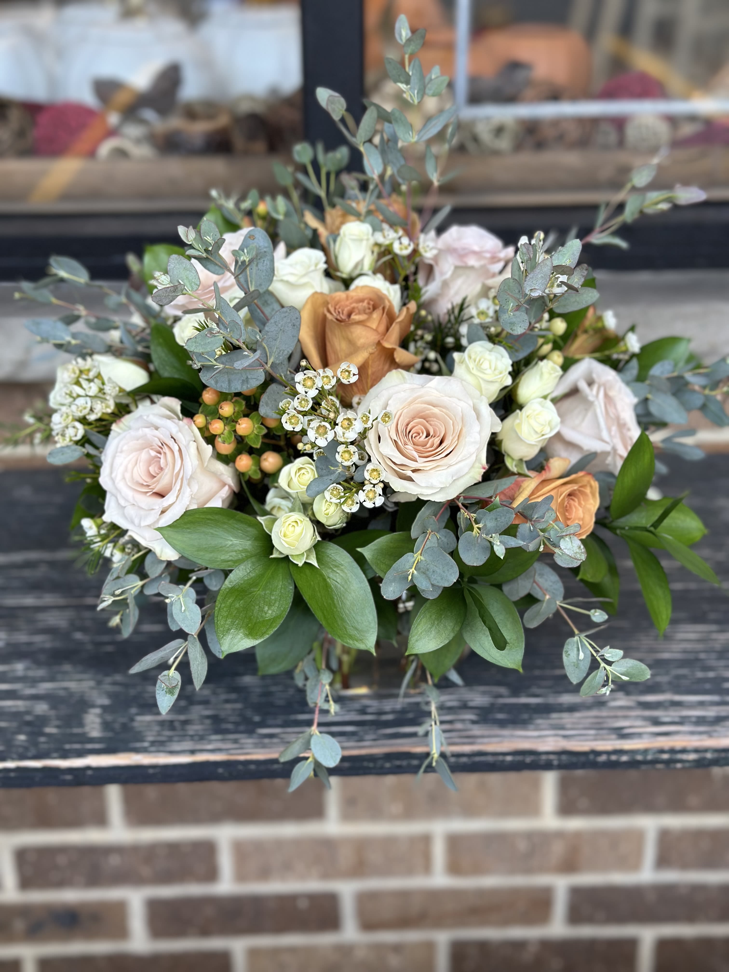 Thanksgiving Centerpiece  - Celebrate the season with this warm and inviting centerpiece. Crafted with coffee and quick sand roses, white spray roses, eucalyptus, white wax flowers, and ruscus, its  the perfect touch of elegance and natural beauty for your family Thanksgiving dinner.