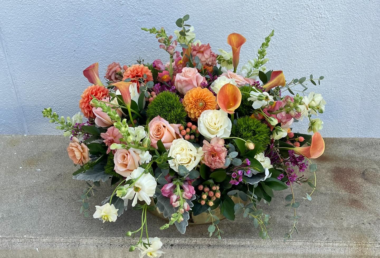 Touch of Fall Touch of Fall - Touch of Fall is a stunning, large, upscale arrangement that includes Dahlia, calla lily, roses, snapdragons, hypericum, wax flowers and a mix of greens in a golden pot.